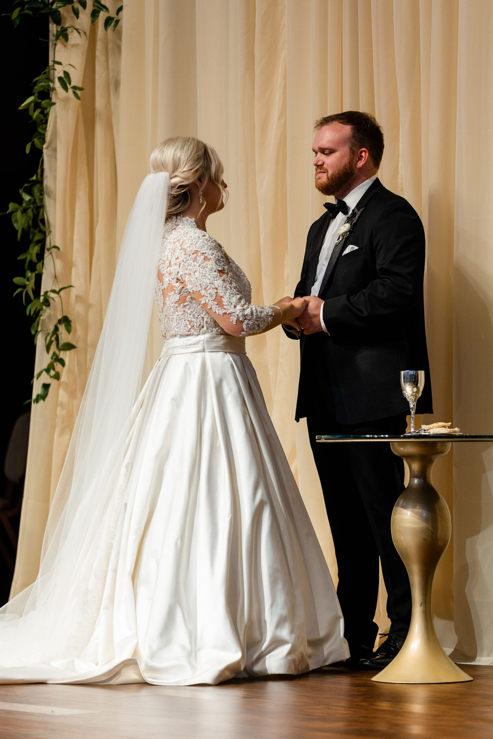 The bride and groom hold hands during their Southern wedding ceremony.