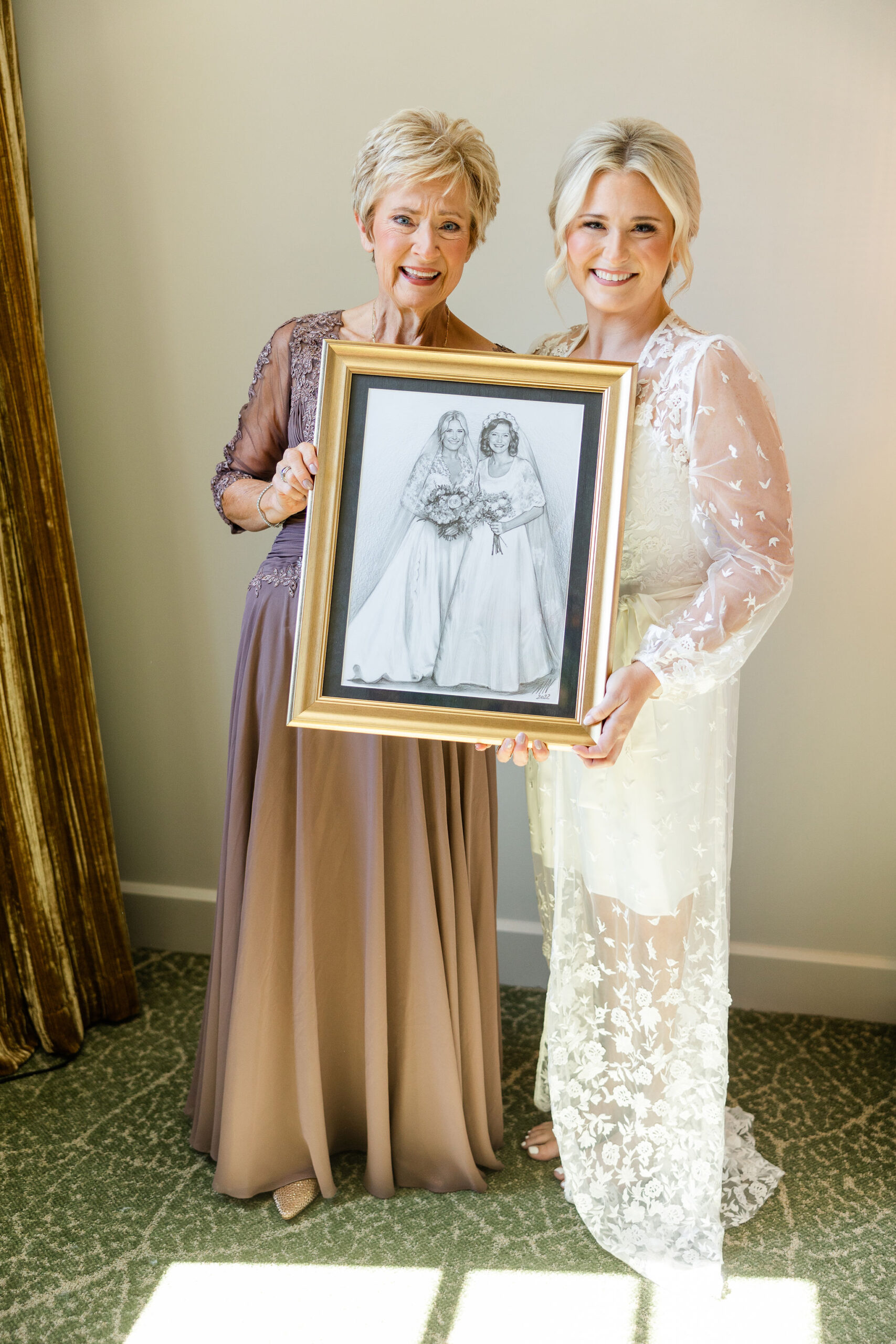 The mother and daughter hold an illustration together at Grand Bohemian Hotel Mountain Brook.