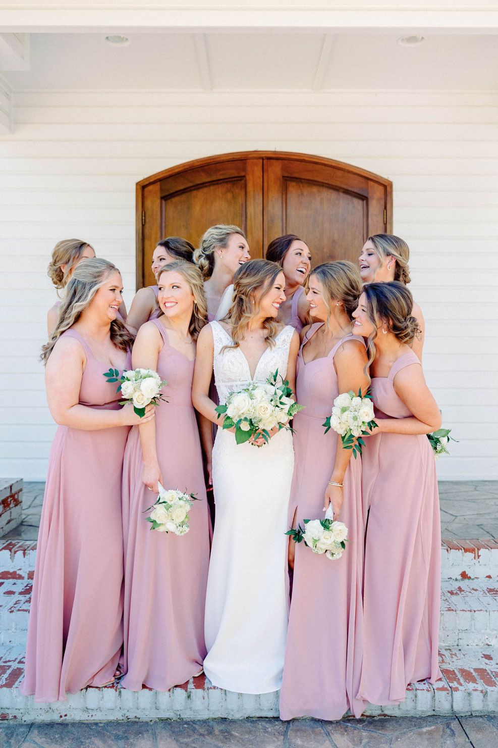 The bride smiles with her bridesmaids before the Southern wedding.