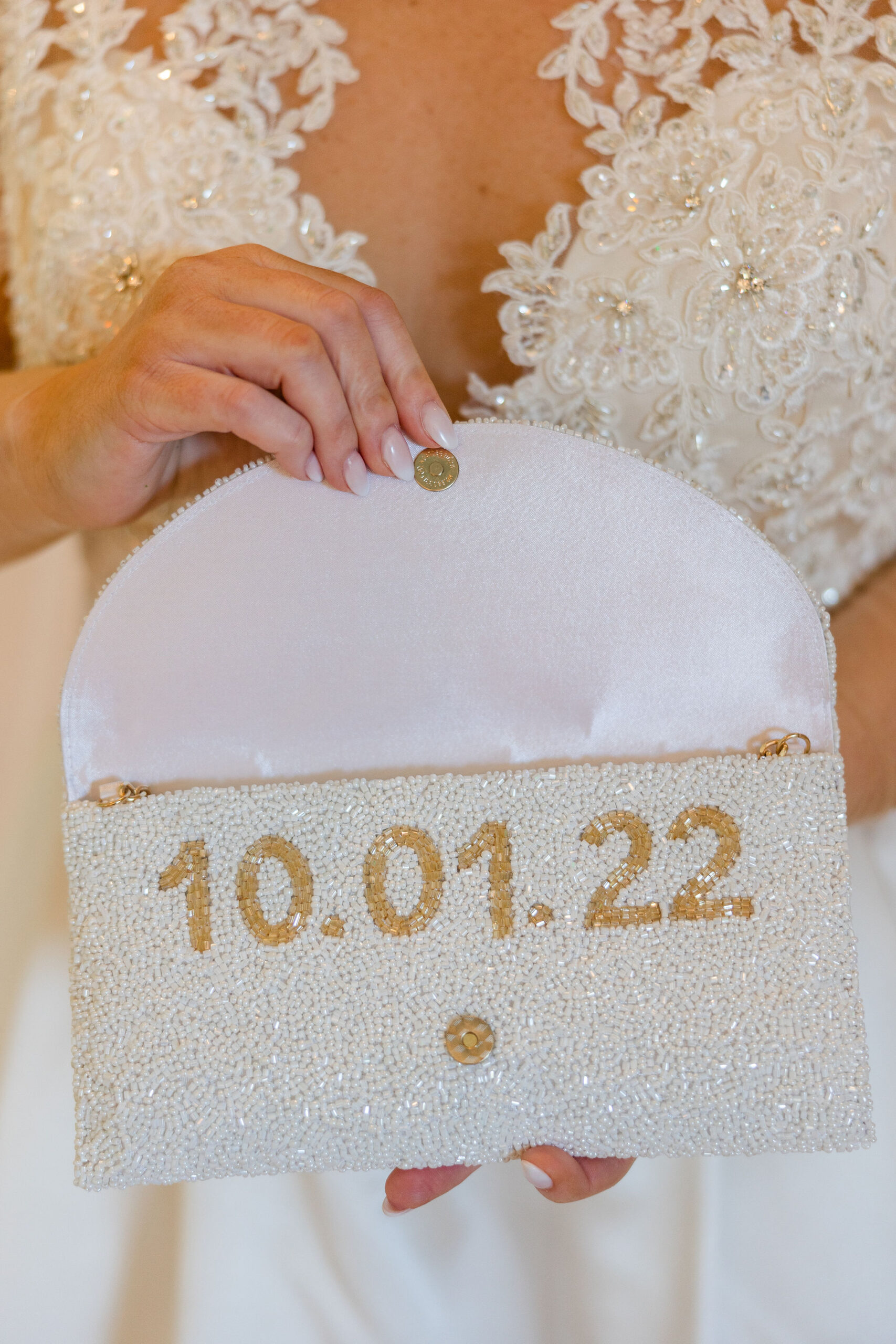 The bride displays her custom clutch for her Southern wedding.