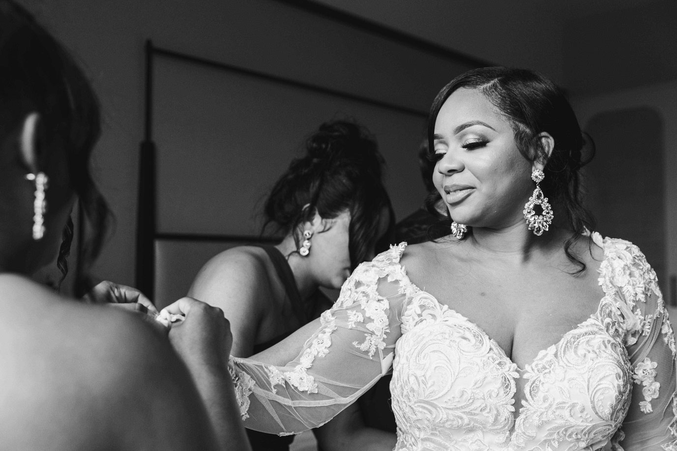 The bridesmaids help the bride into her wedding dress at The Valley Hotel in Birmingham.