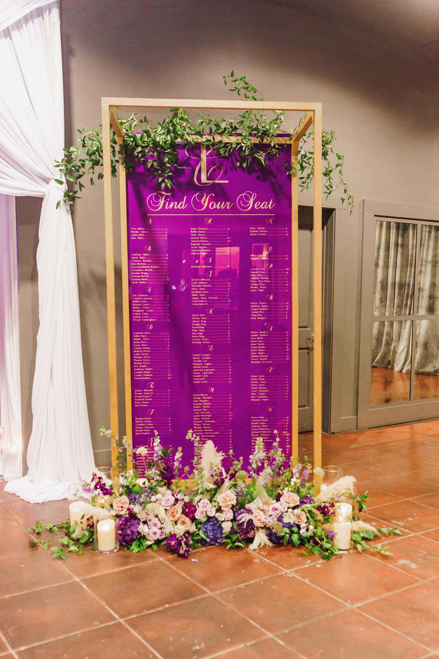 The unique seating chart is decorated with flowers and candles outside the reception hall at Haven.