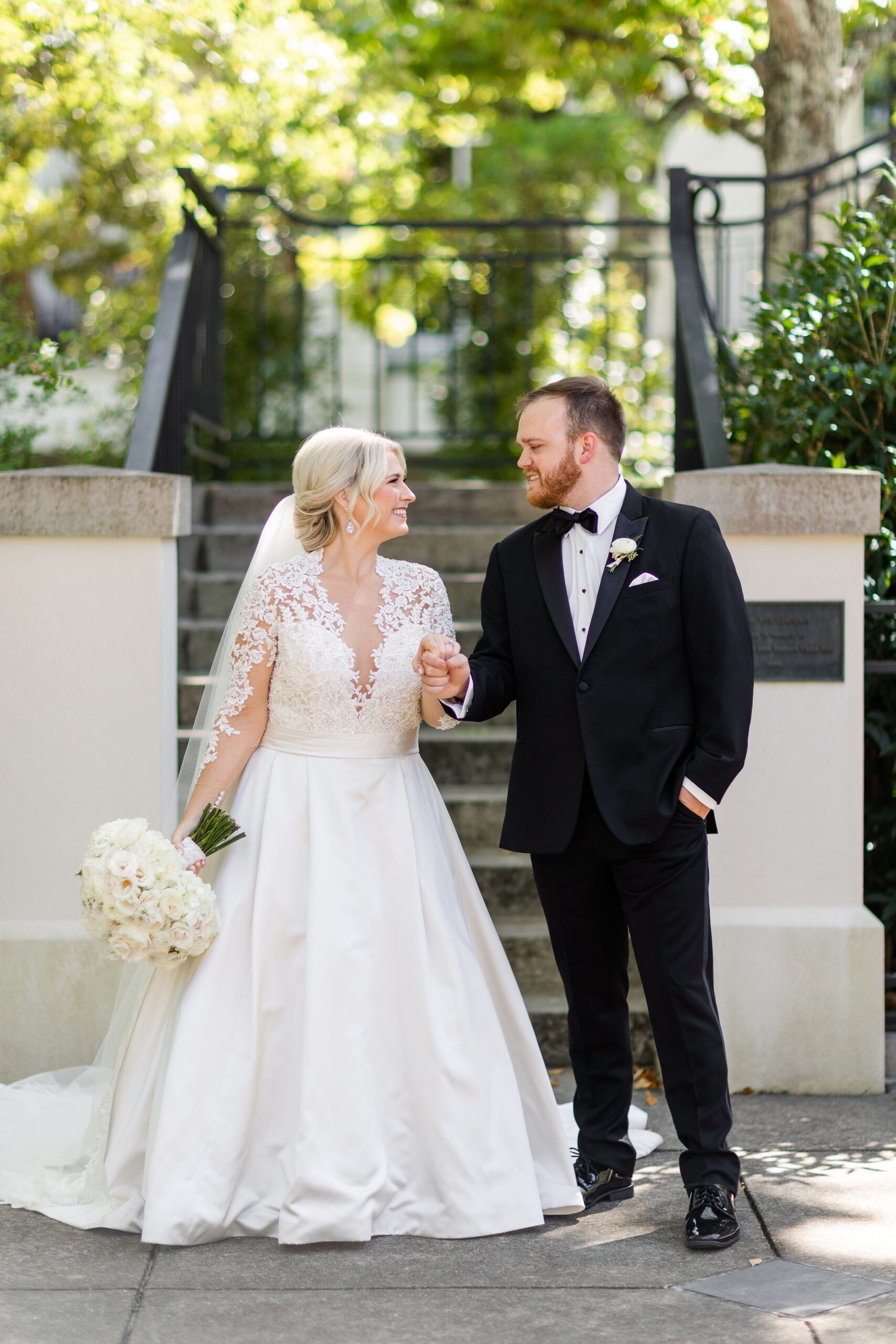 The bride and groom hold hands at Birmingham Botanical Gardens.