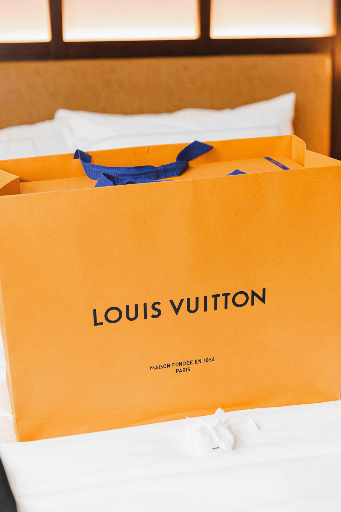 A Louis Vuitton bag sits on the bed at The Valley Hotel.