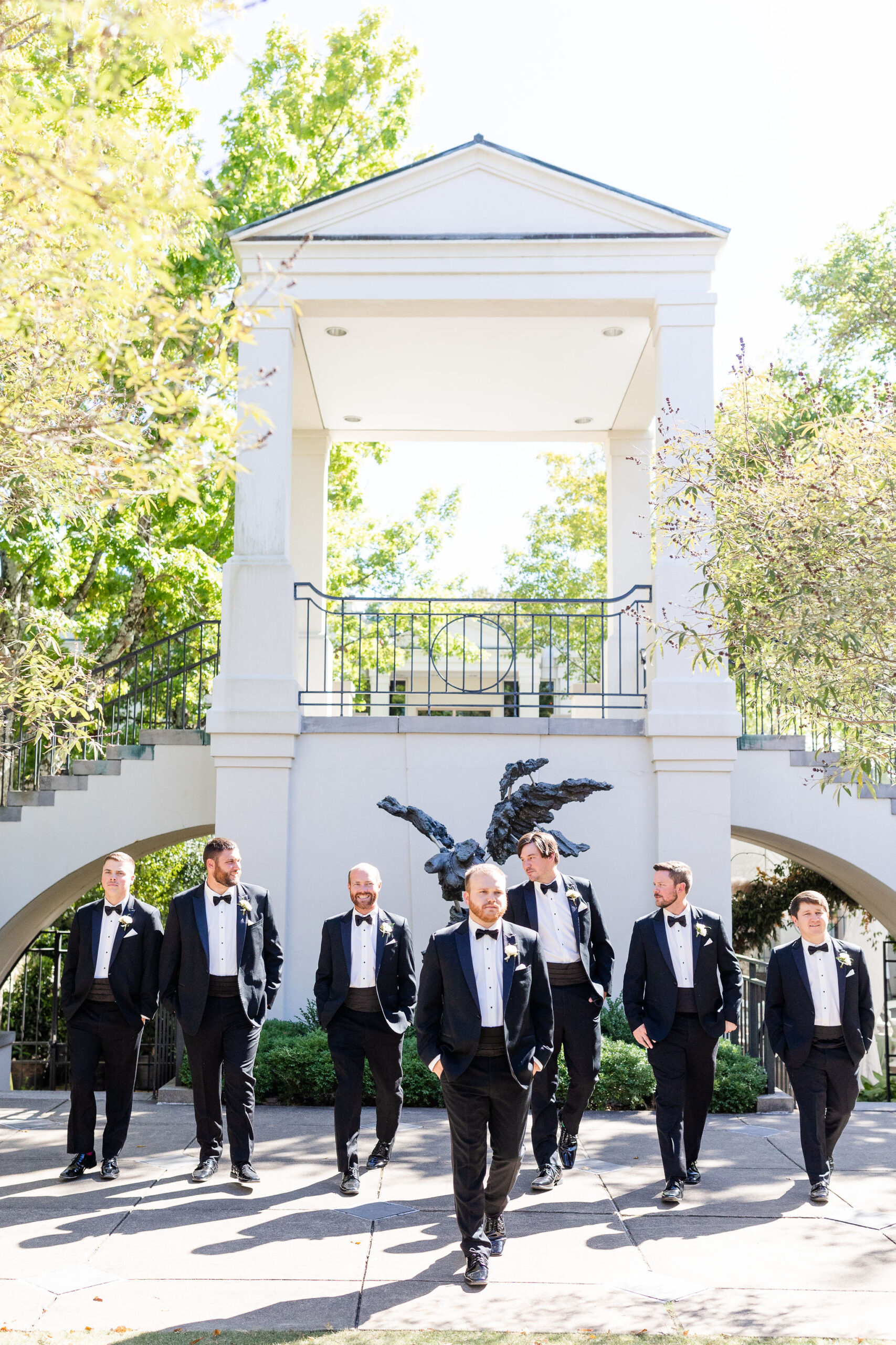 The groomsmen walk together at Birmingham Botanical Gardens.