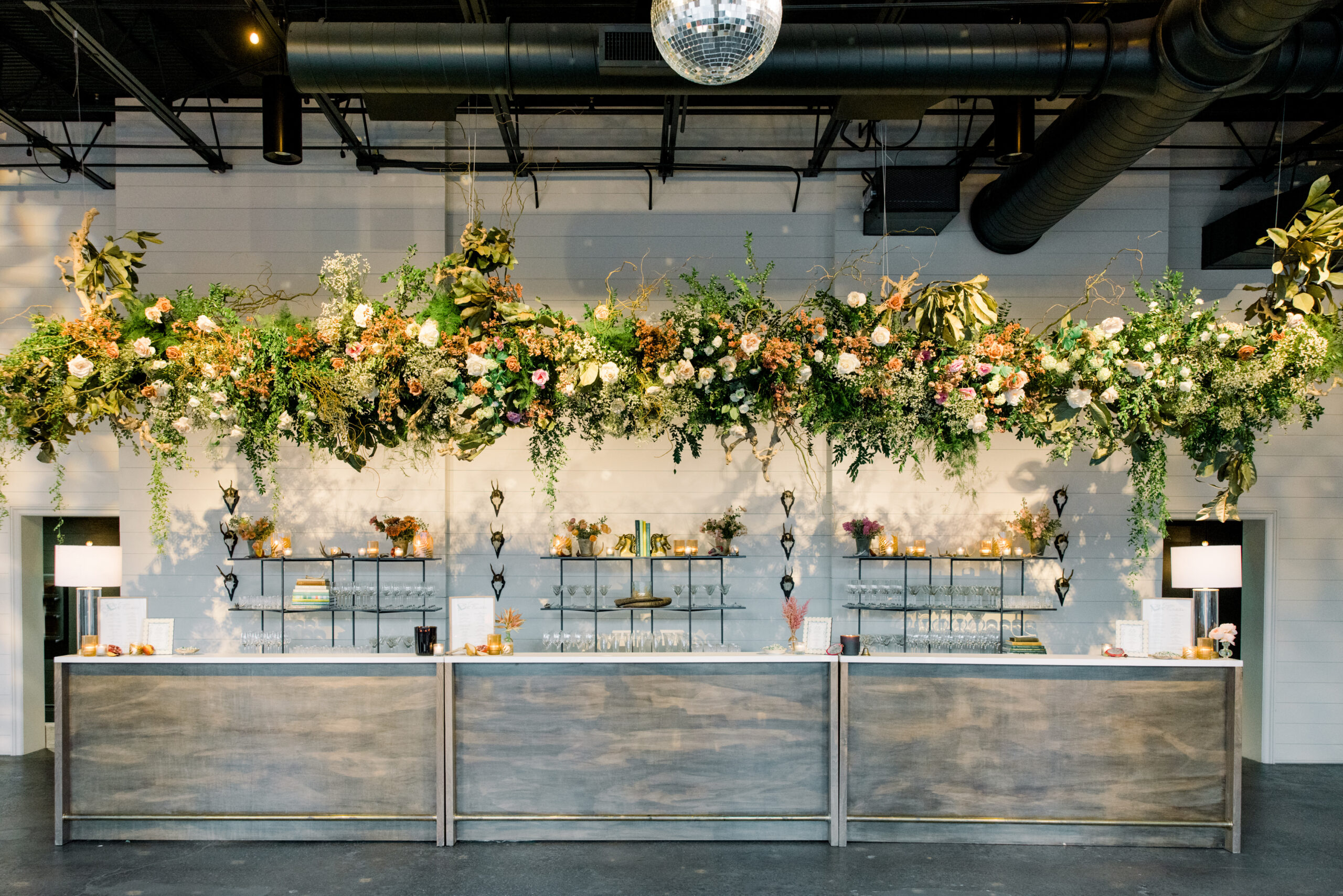 A large floral design installation is suspended above the bar at the Farrell for the Alabama Weddings party.