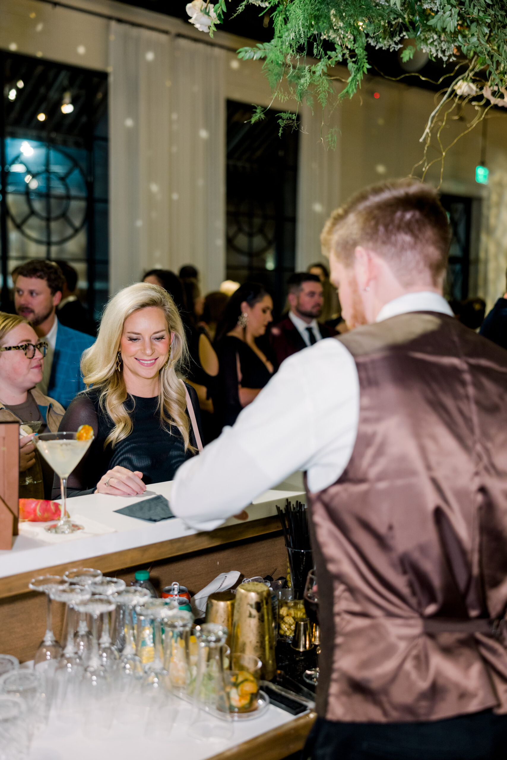 A lady orders a cocktail at the bar for the Alabama Weddings party.