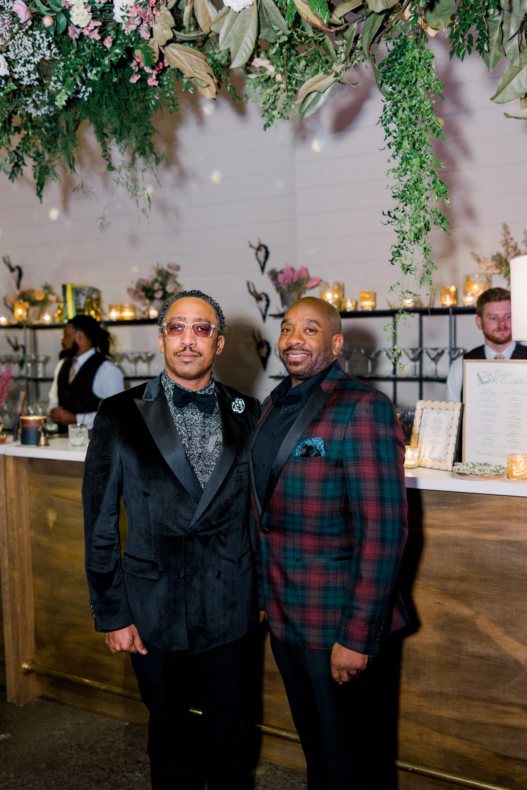 Two gentlemen pose in front of the bar at the Alabama Weddings party in Birmingham.