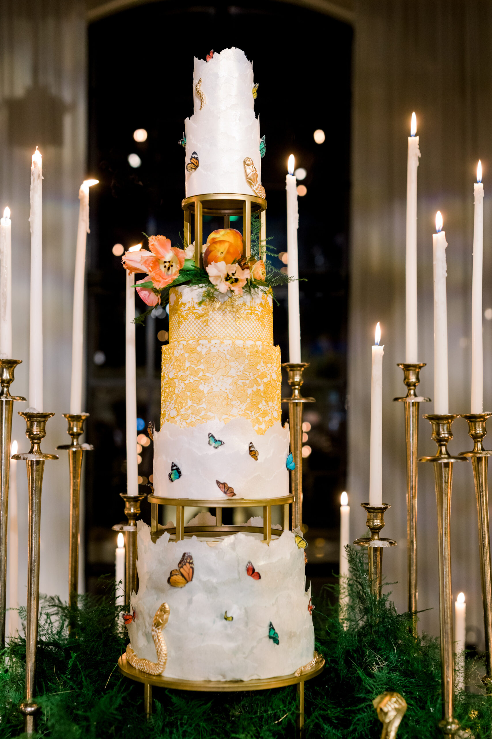 The wedding cake is decorated with snakes and butterflies at the Alabama Weddings party.