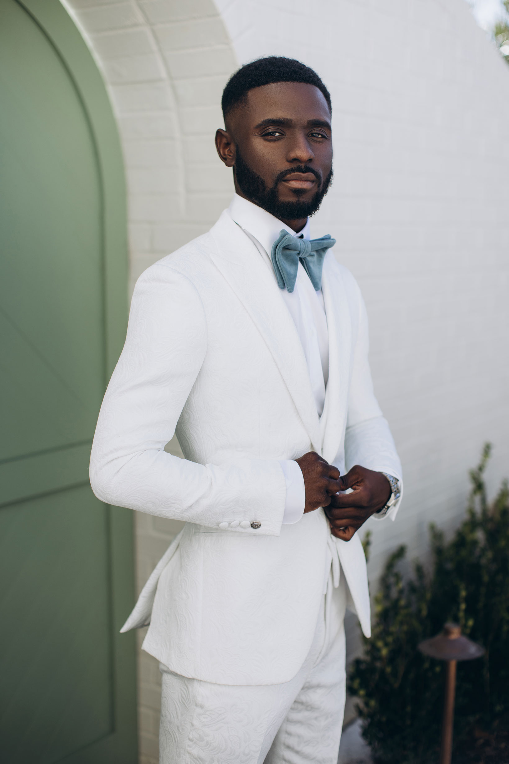 The groom wears a white tuxedo for his Birmingham wedding.