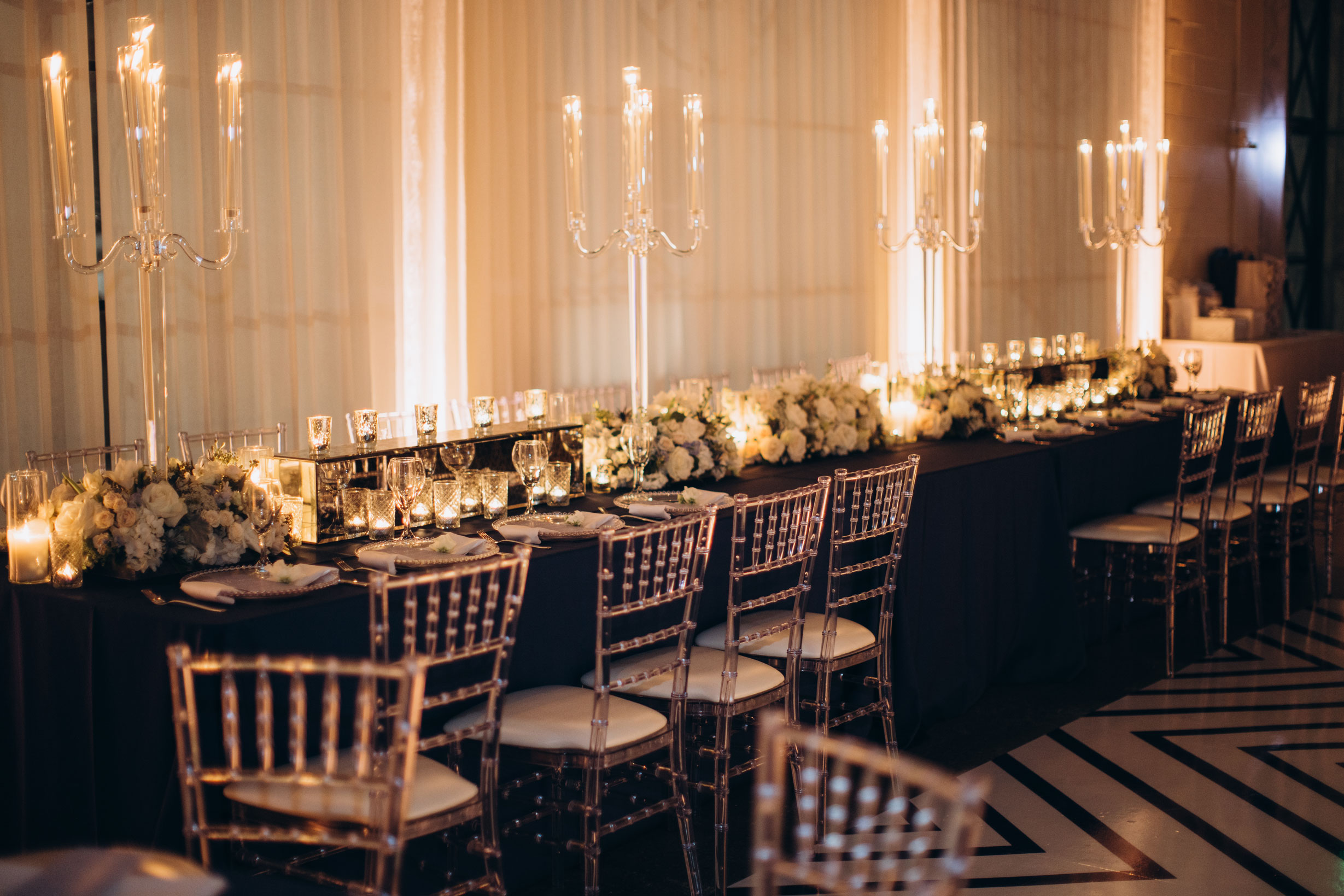 The head table for the wedding reception at The Farrell features candelabras and flowers.