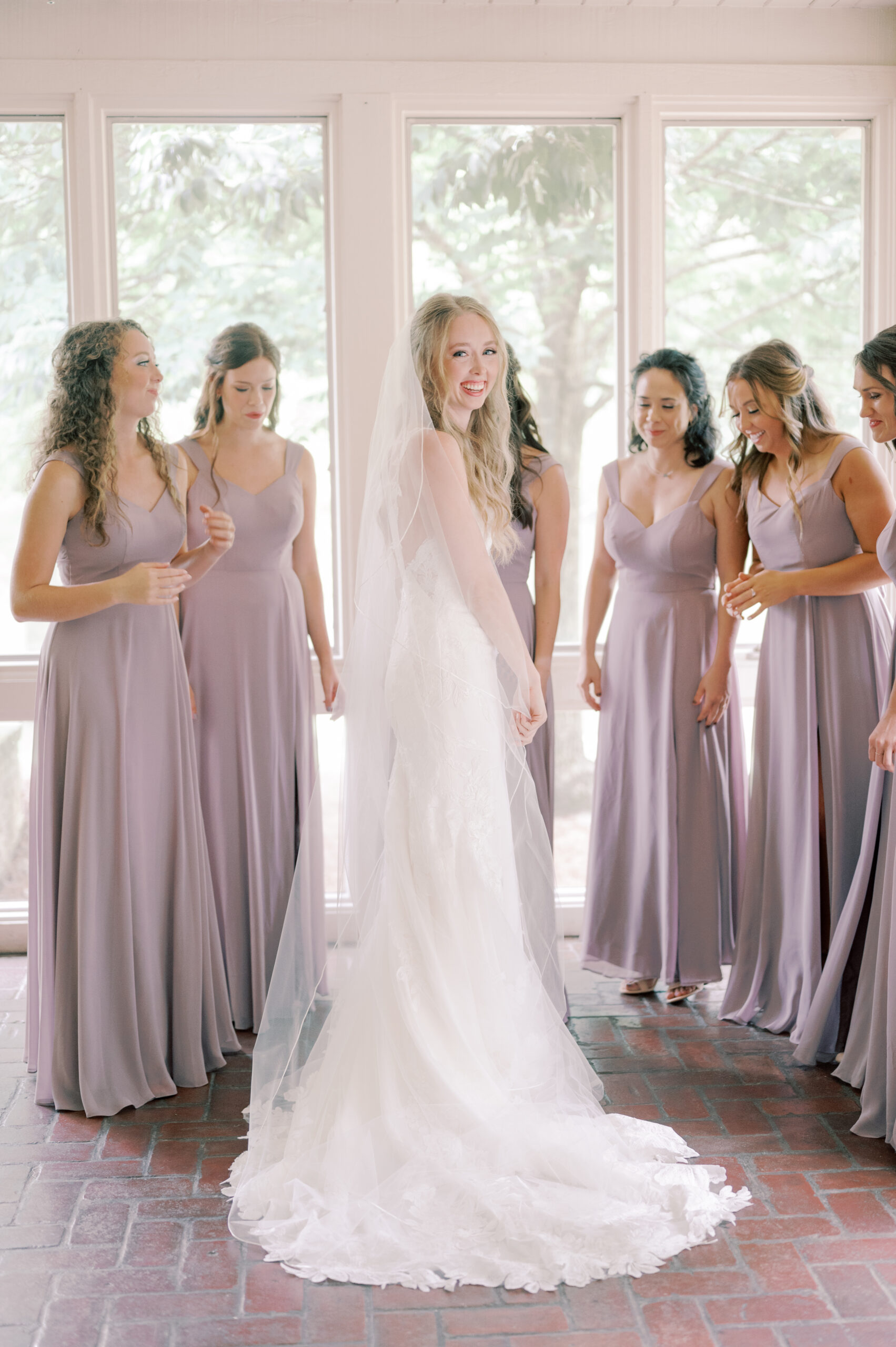 The bridesmaids admire the Southern bride in her wedding dress.