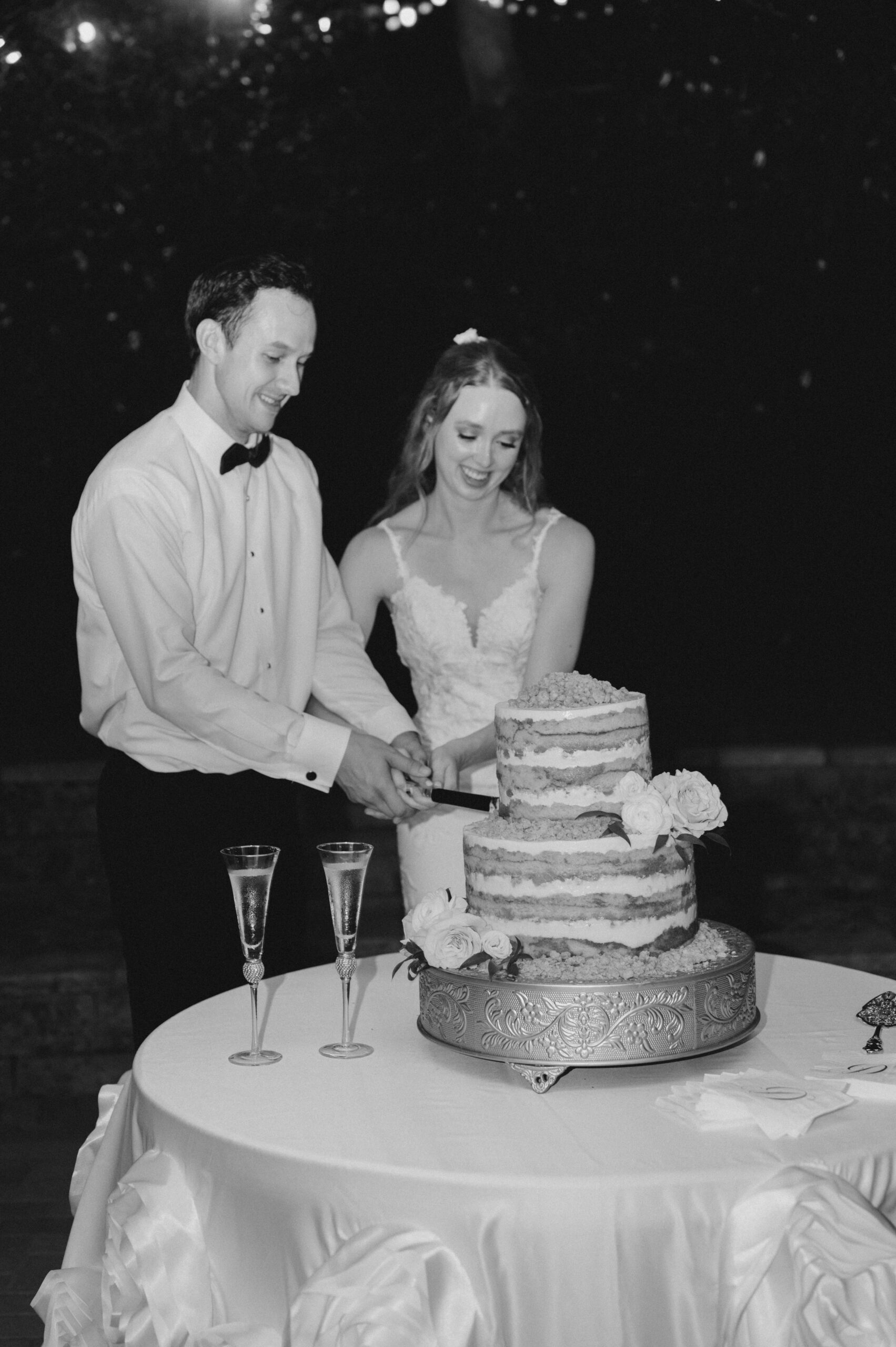 The bride and groom cut their cake by Daughter's Baking during this garden wedding reception.