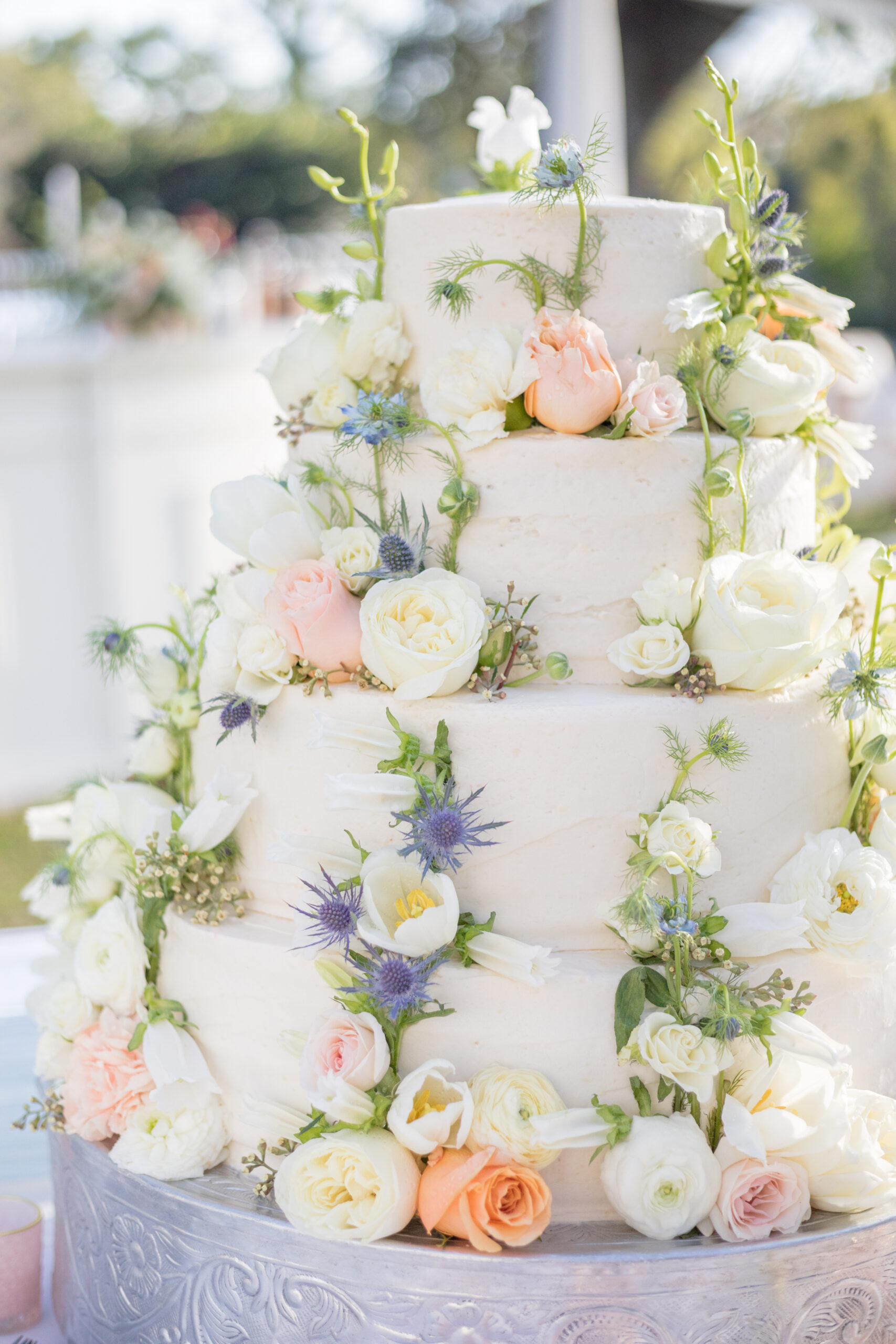 The spring wedding cake is decorated with fresh flowers for the reception in Mobile, Alabama.