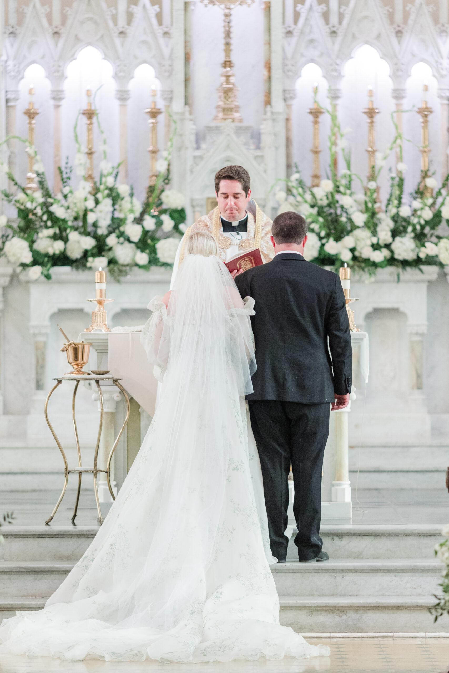 The bride and groom stand at the altar together during their wedding ceremony in Mobile, Alabama.