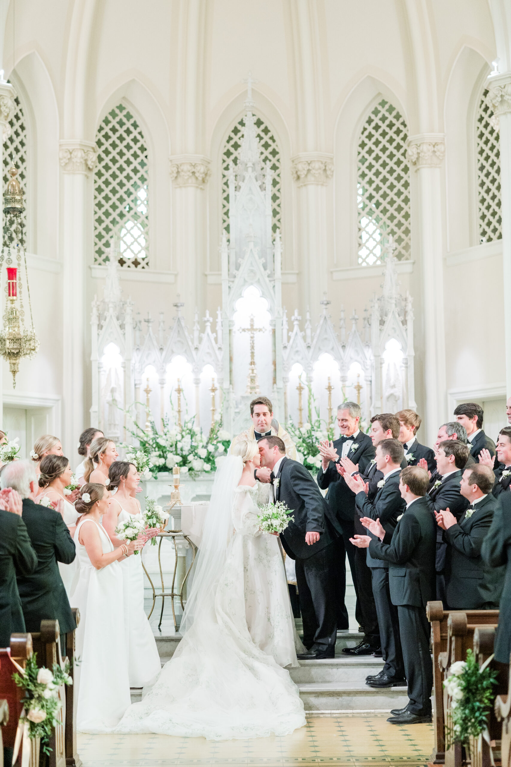 The groom kisses the bride at the wedding ceremony in Mobile, Alabama.