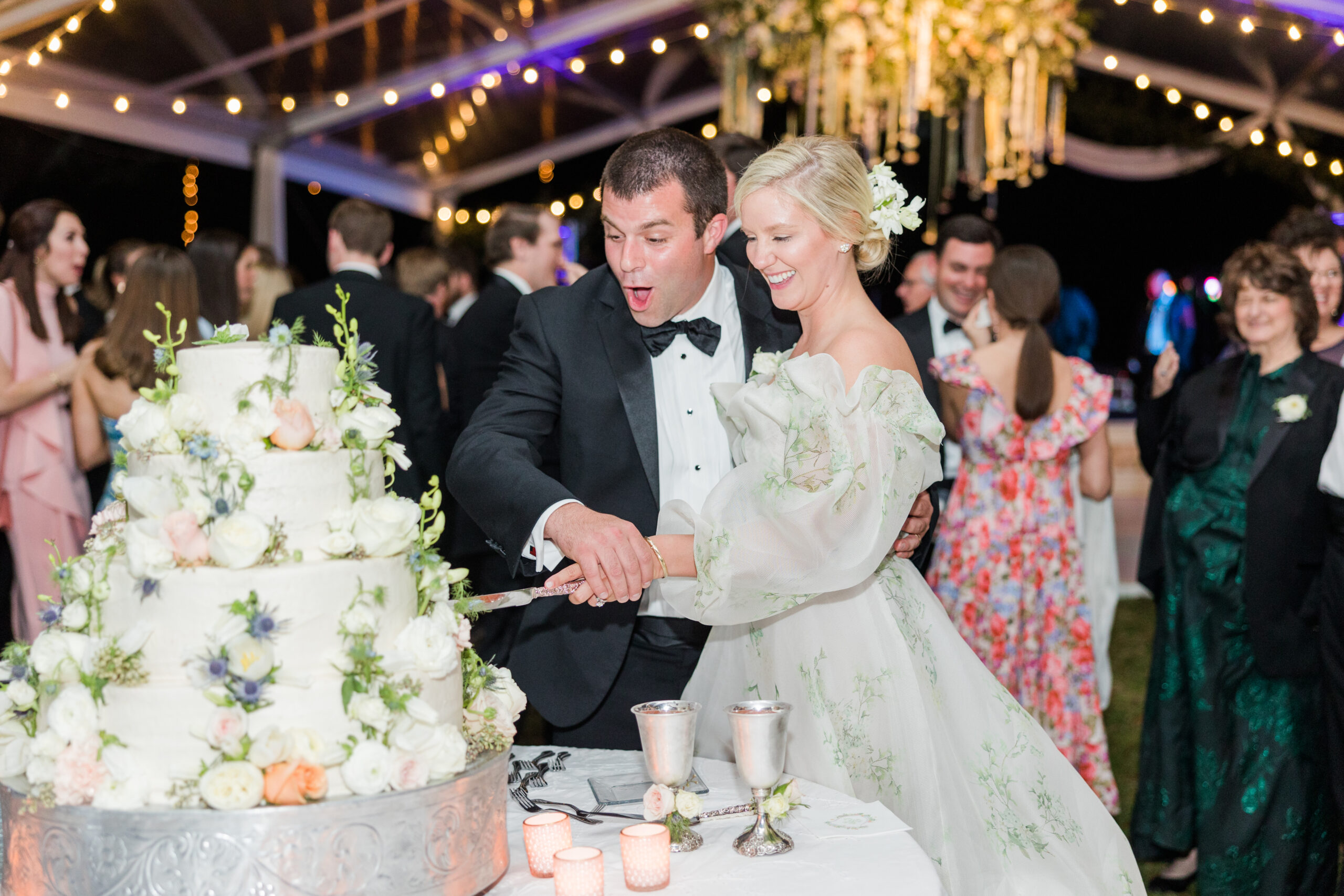 The bride and groom cut the cake during their spring wedding reception in Mobile, Alabama.