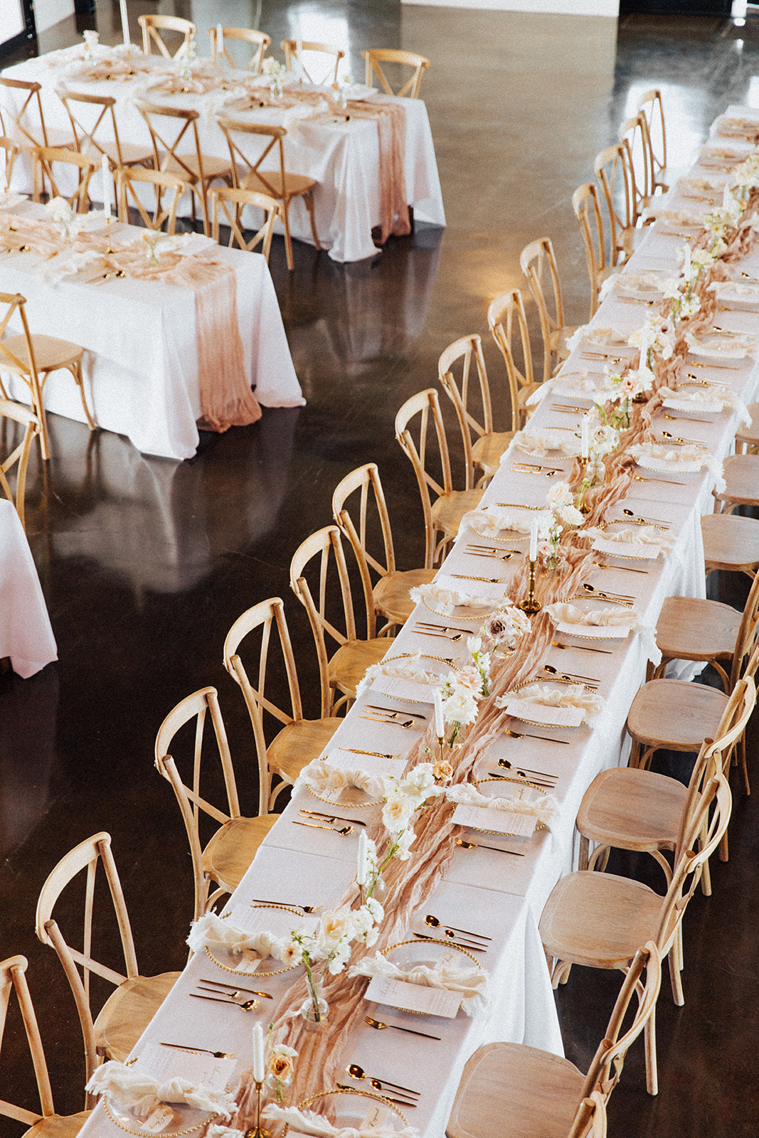 Tables are set with bud vase flowers and silk runners for the Alabama wedding reception.