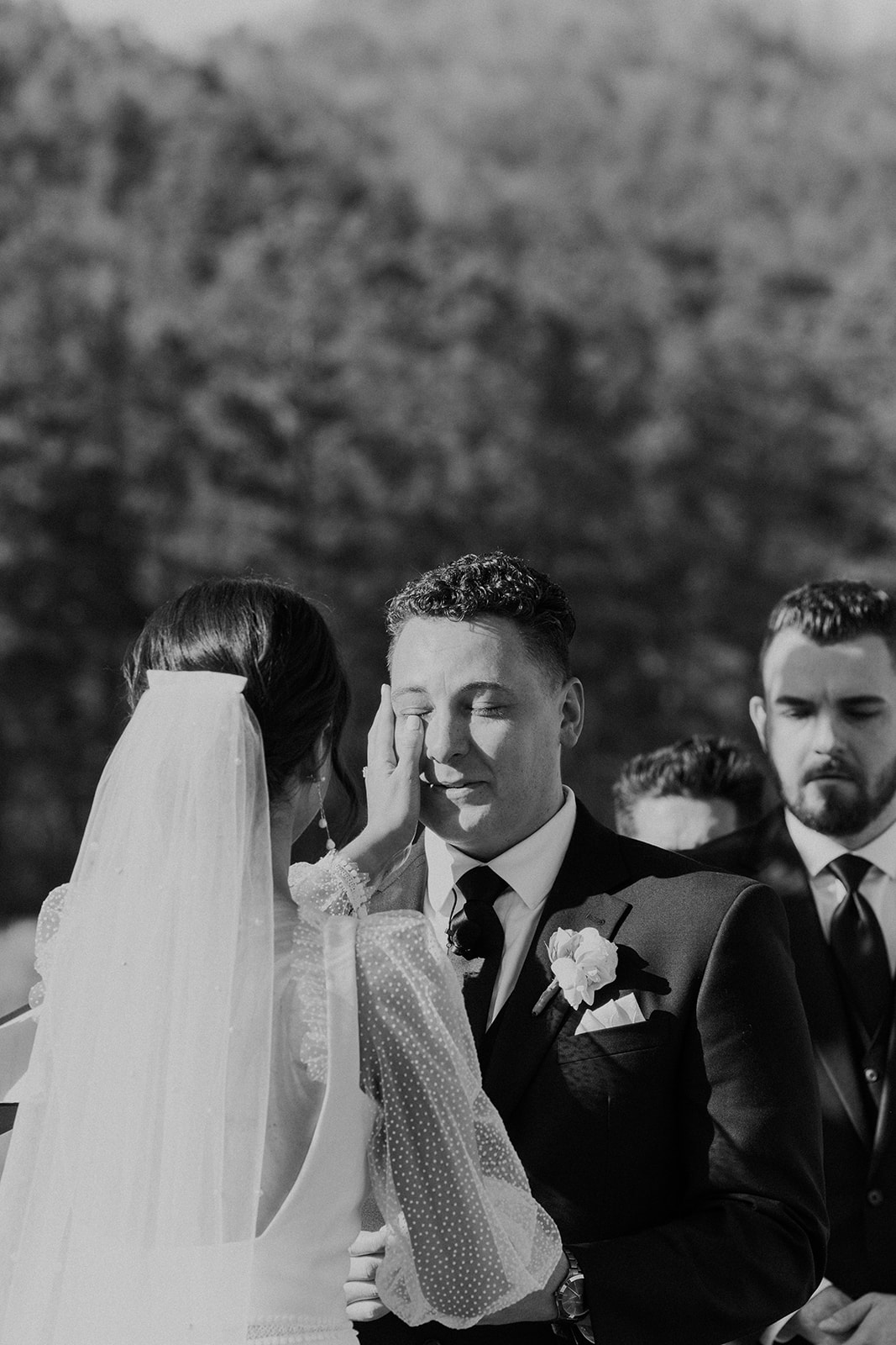 The bride wipes the groom's tears during their wedding ceremony in Alabama.