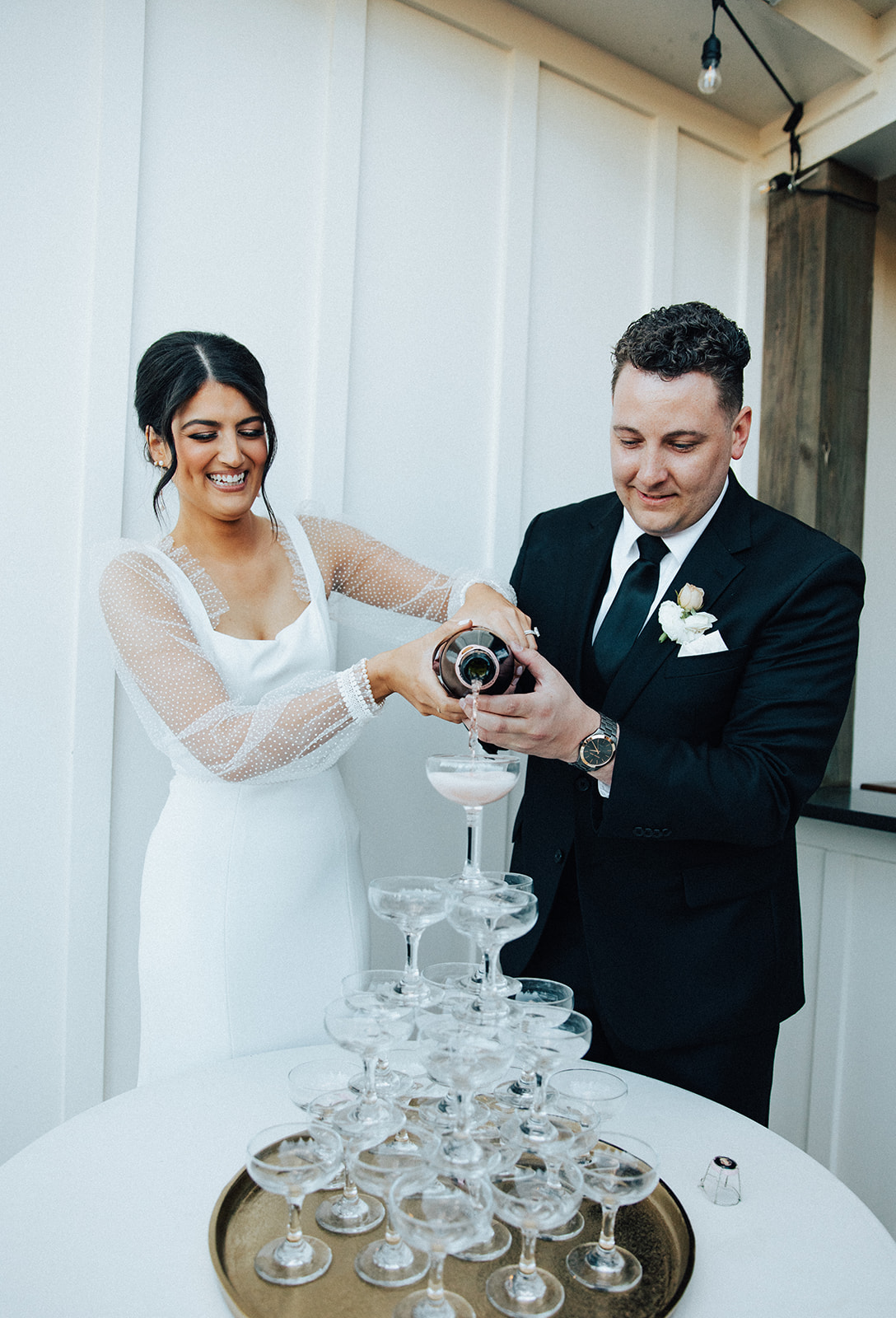 The couple pours champagne during their Alabama wedding reception.