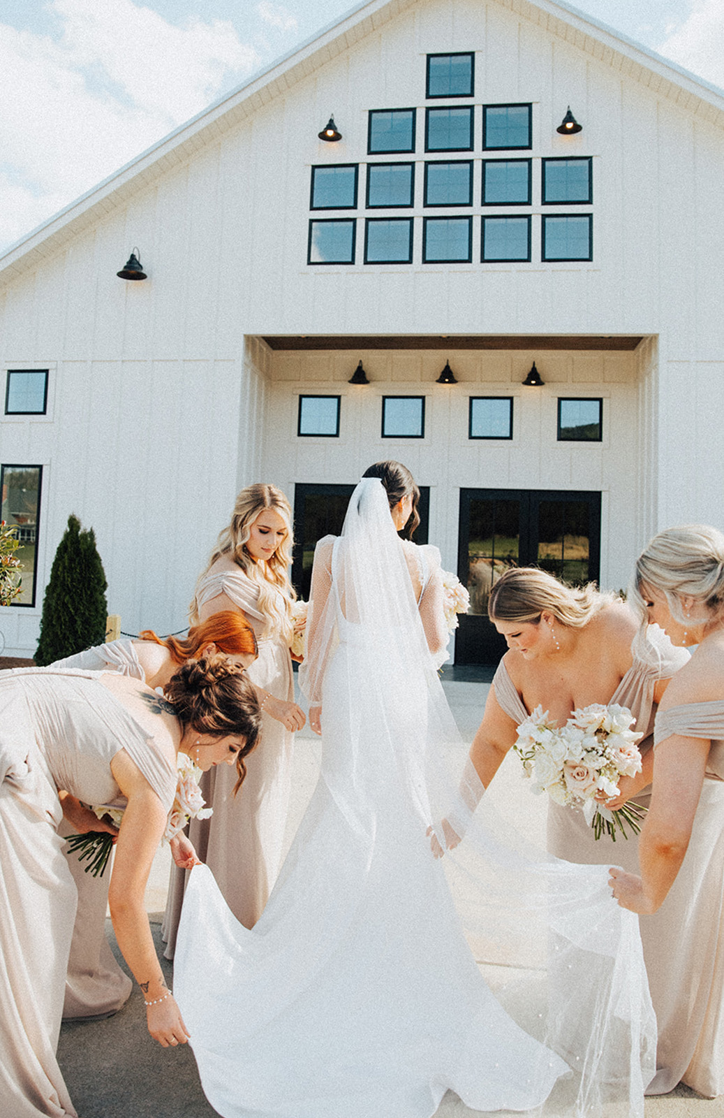 The bridesmaids help the bride with her wedding dress from Birch on Main in Huntsville, Alabama.