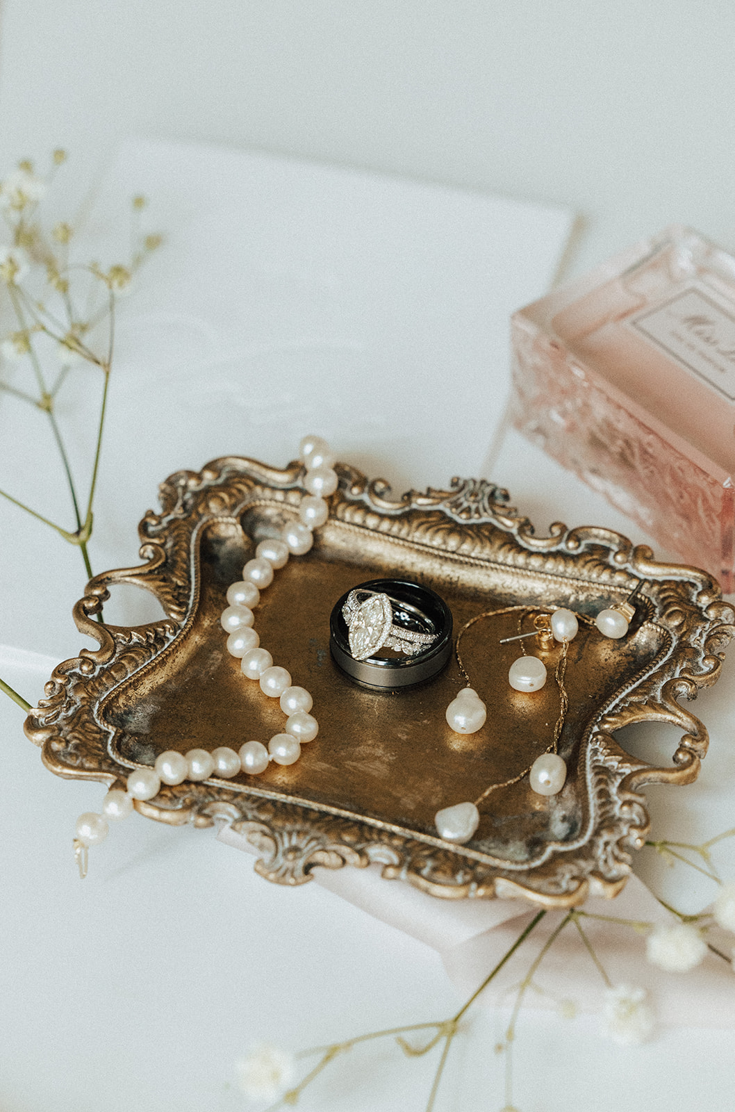 The bride jewelry and the groom's ring are styled on a tray for their North Alabama wedding.