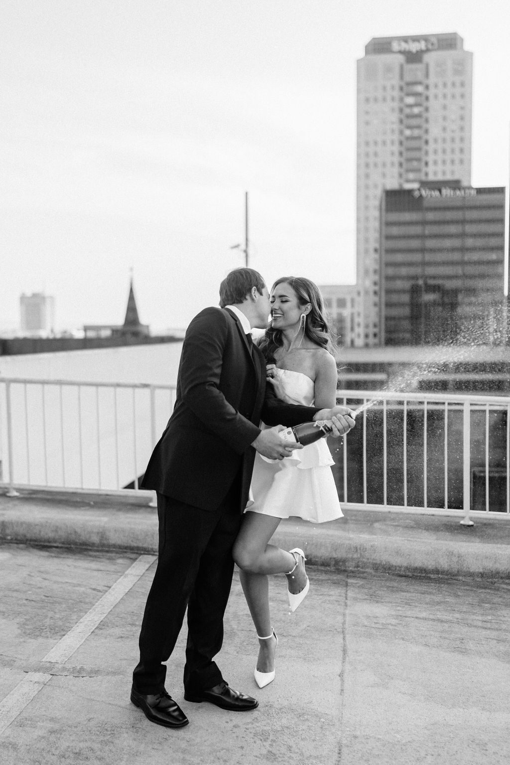 The man pops a bottle of champagne as he kisses his fiancé to celebrate their engagement in Birmingham, Alabama.