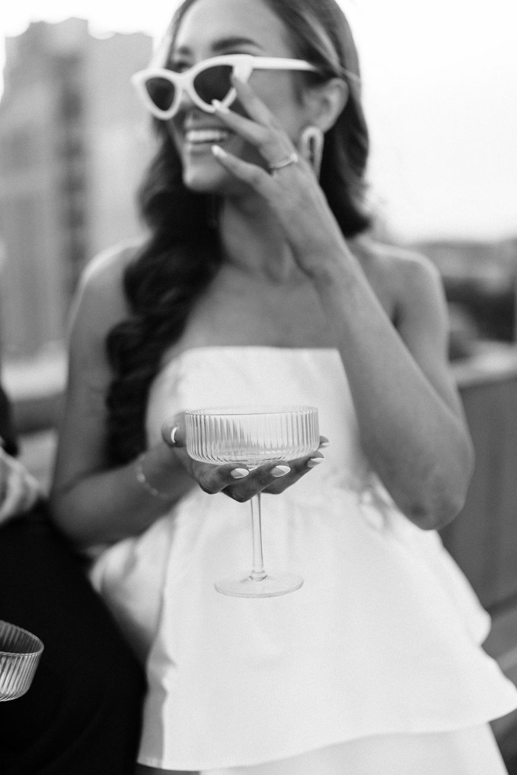 The bride holds a Champagne coup to celebrate her engagement in downtown Birmingham, Alabama.