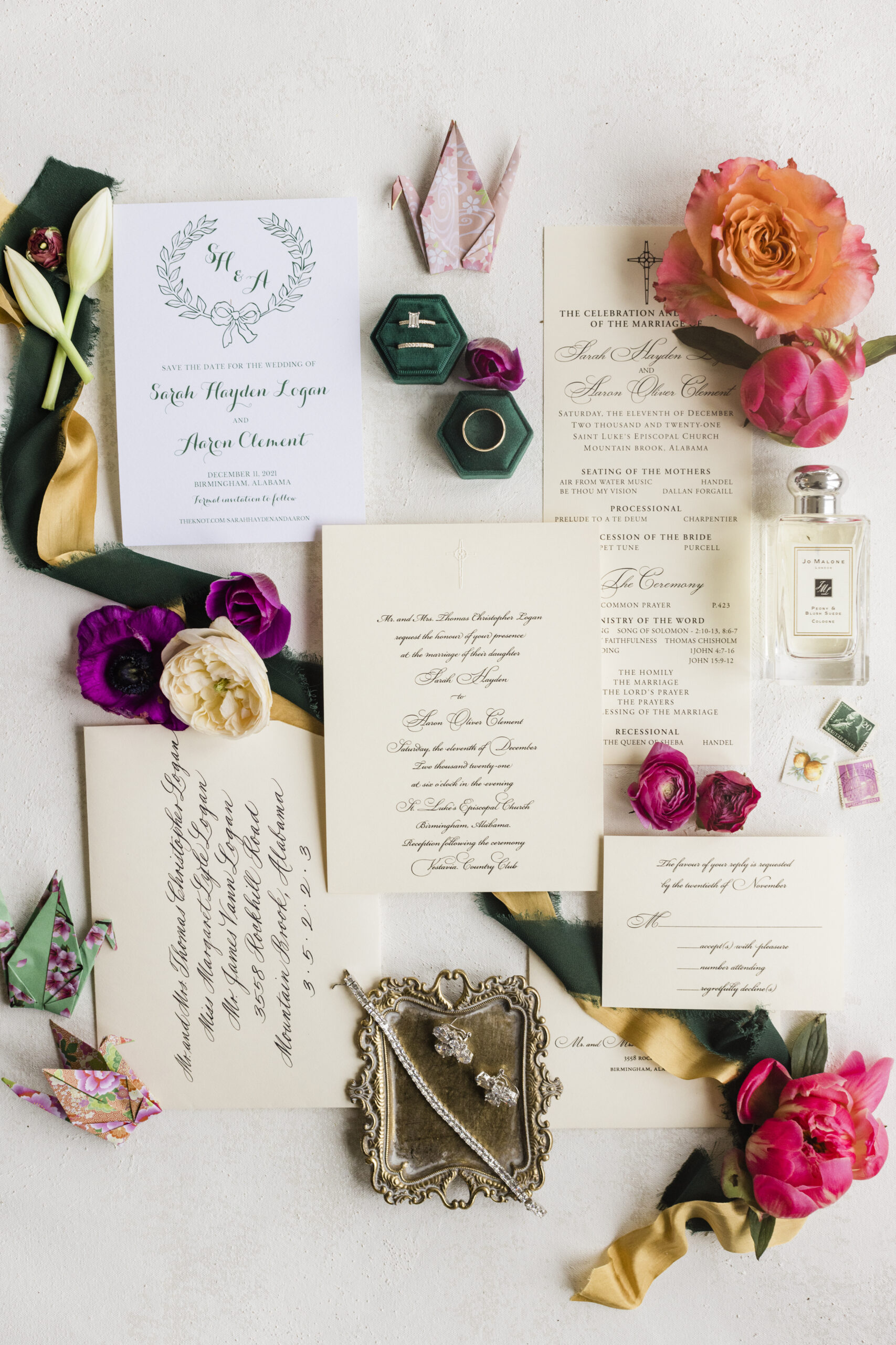 The stationery for the Southern wedding is styled in a lay flat with flowers and origami cranes.