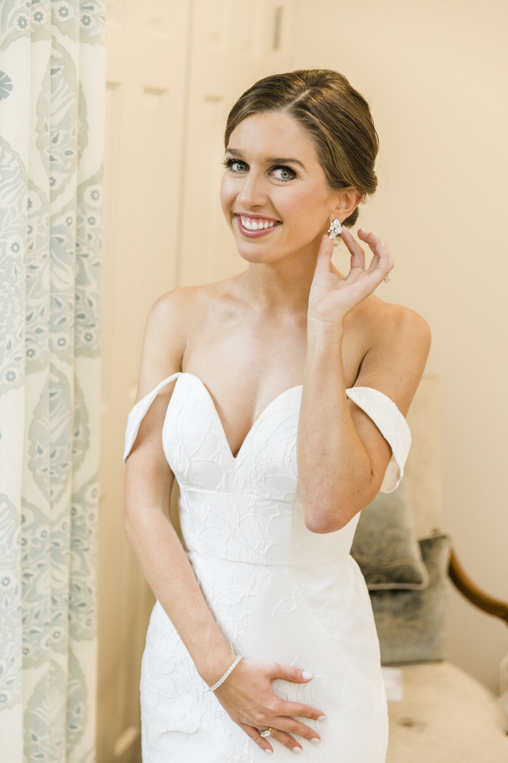 The bride shows off her bridal earrings.