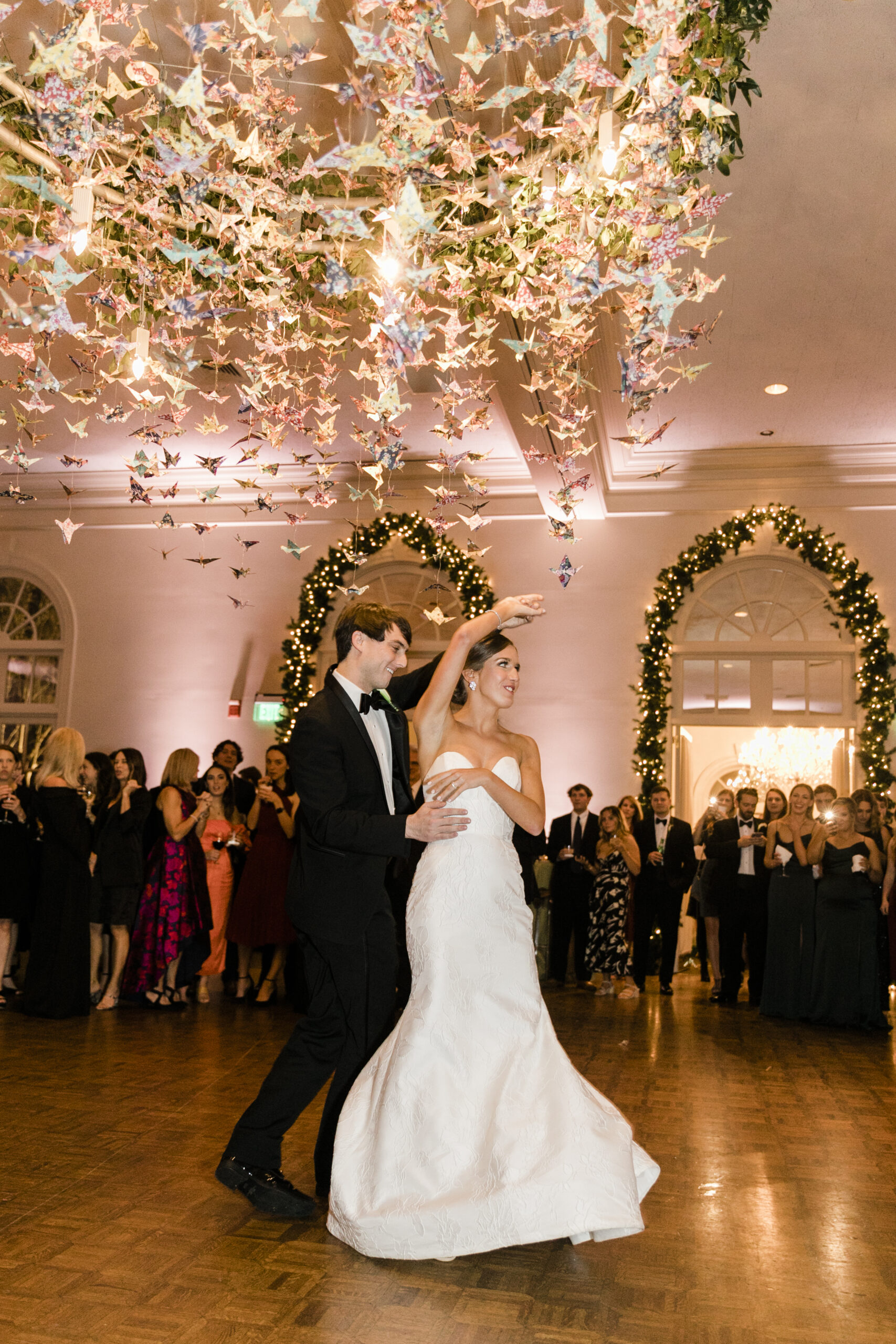 The bride and groom share their first dance under a custom origami chandelier at Vestavia Country Club.