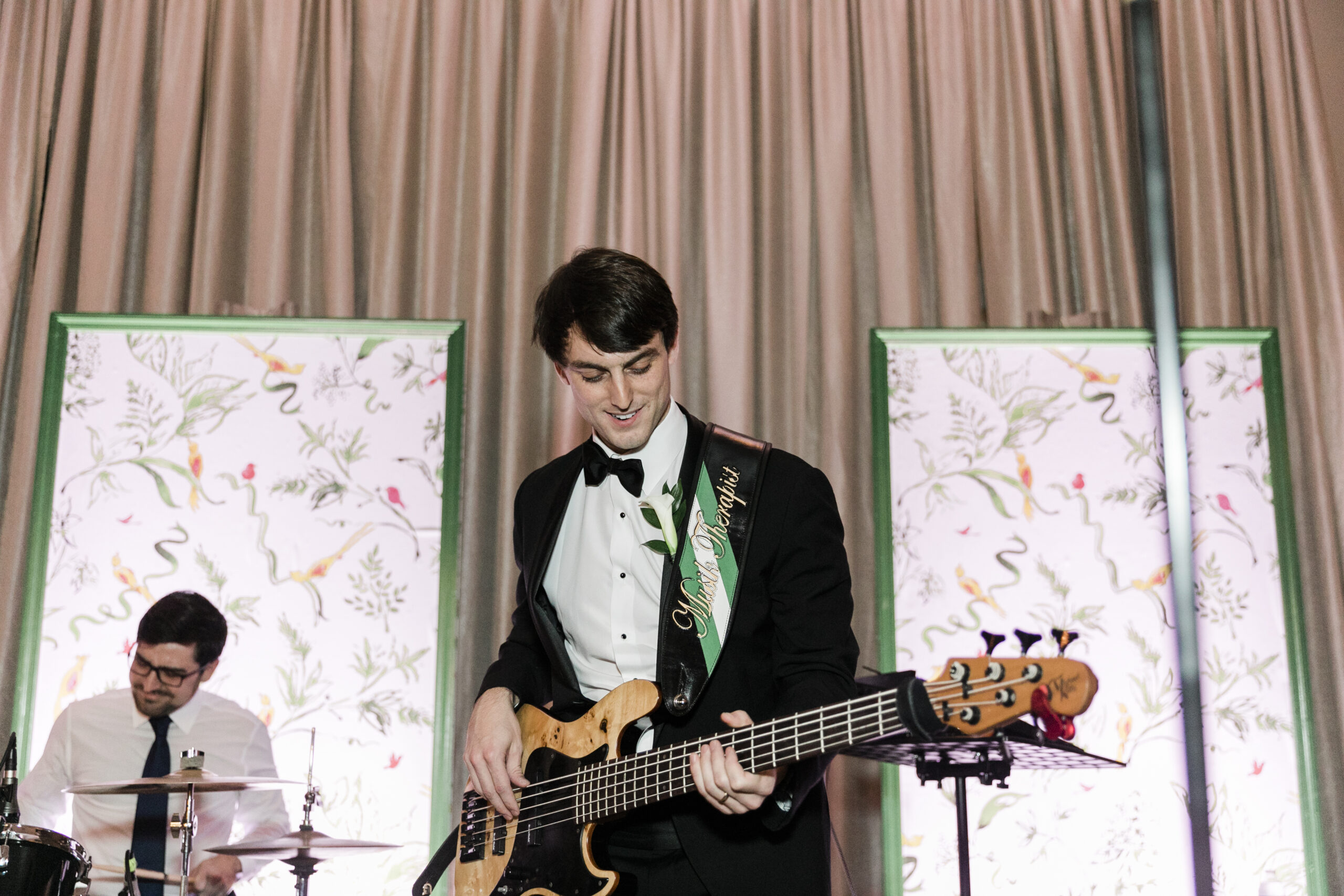 The groom plays the guitar with his band at his wedding reception.