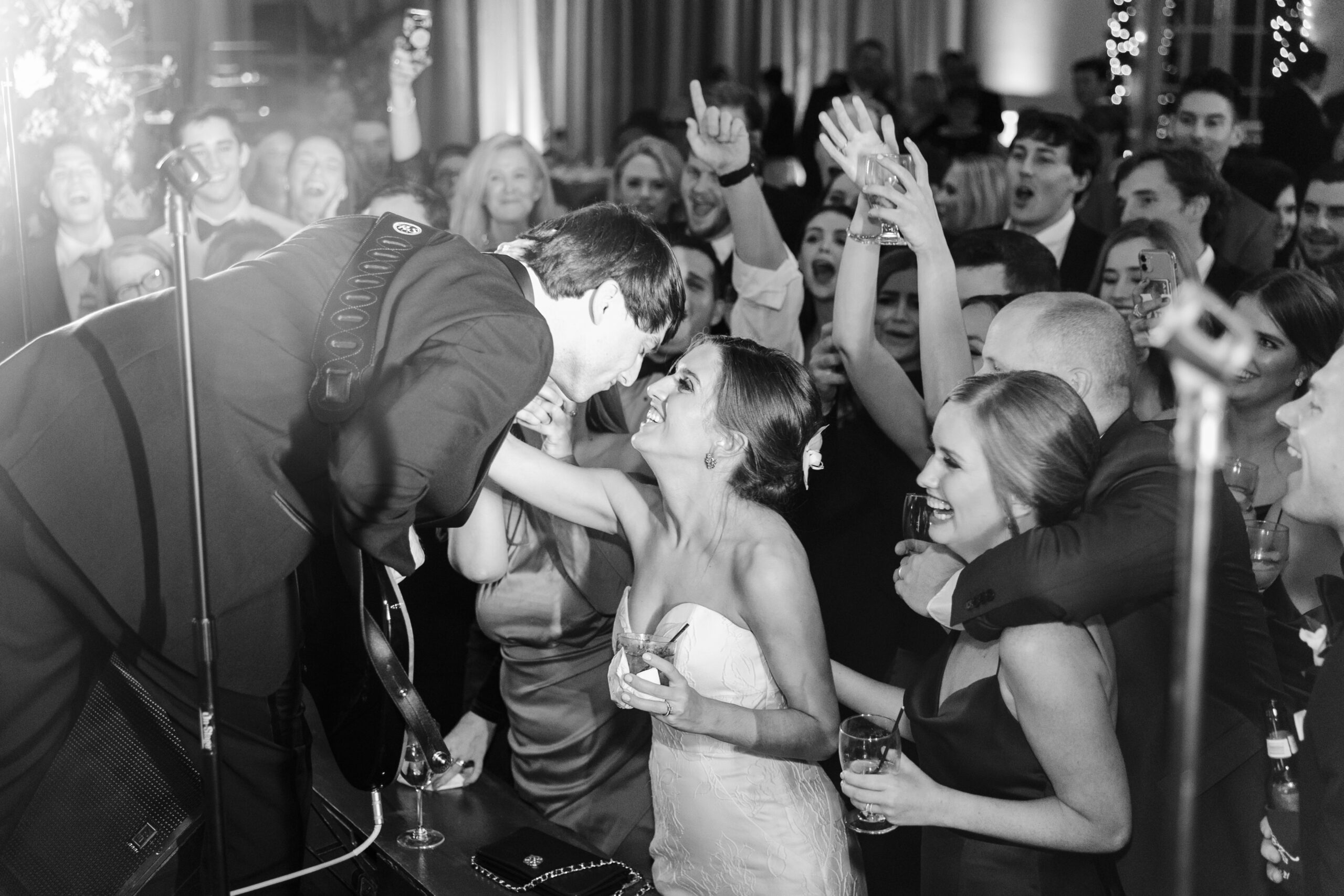 The groom leans down from the stage to kiss the bride at the Southern wedding reception.