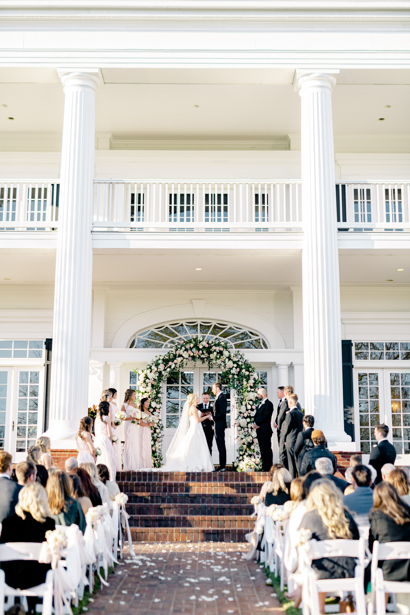 The bride and groom share their vows in front of Marsgate event venue in Alabama.