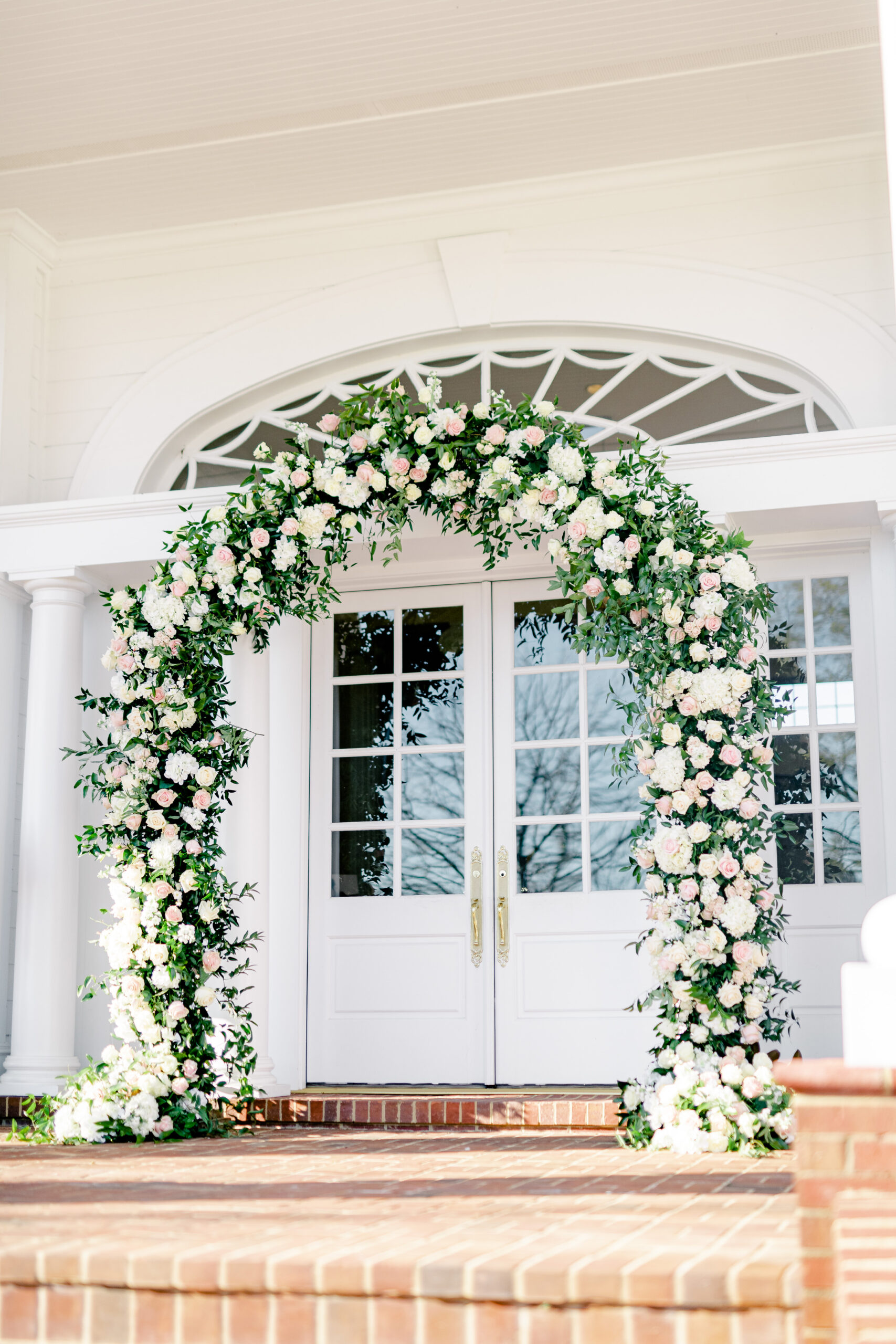 The wedding ceremony at Marsgate is decorated with a floral arch.