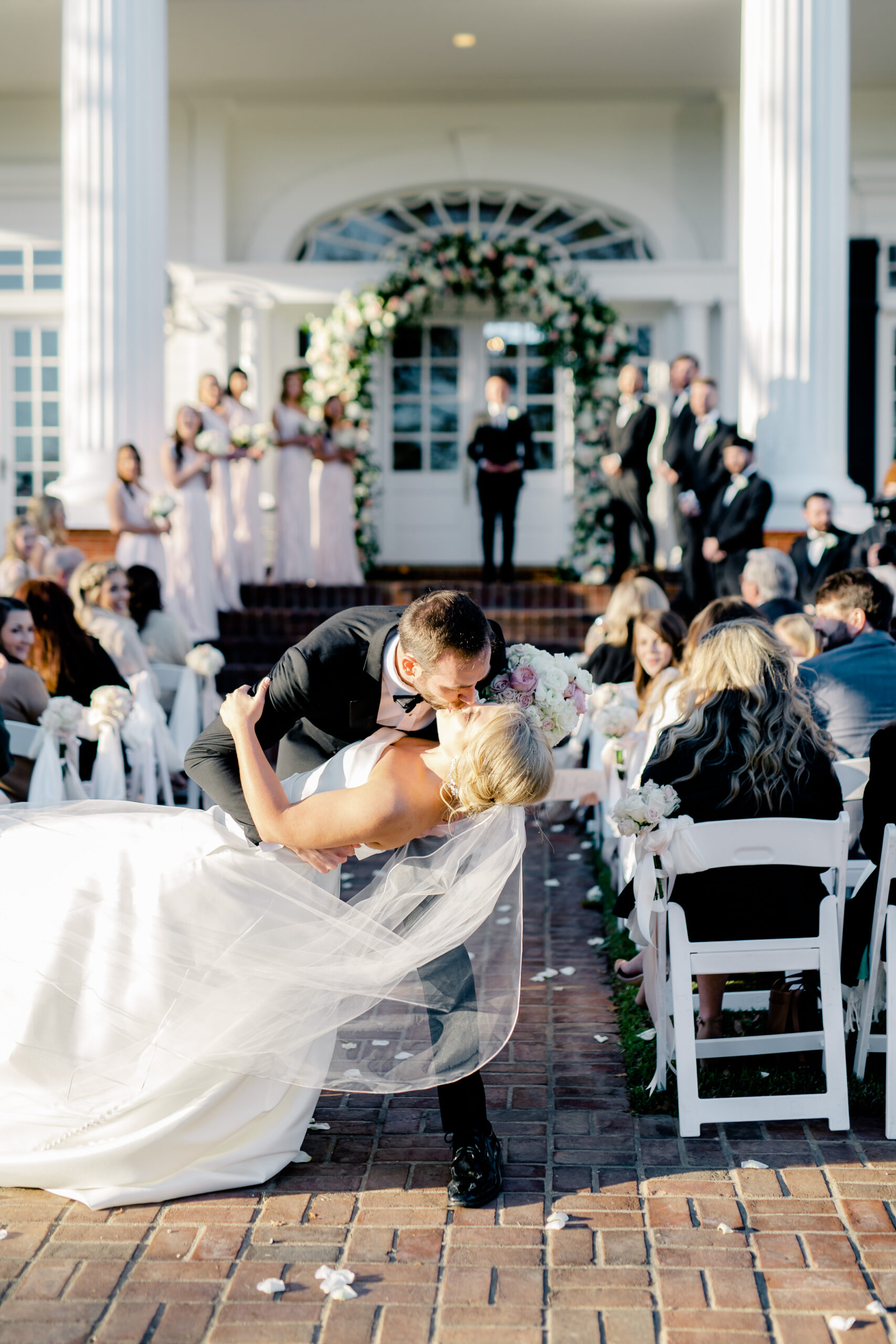 The groom kisses the bride at the end of the aisle at Marsgate.