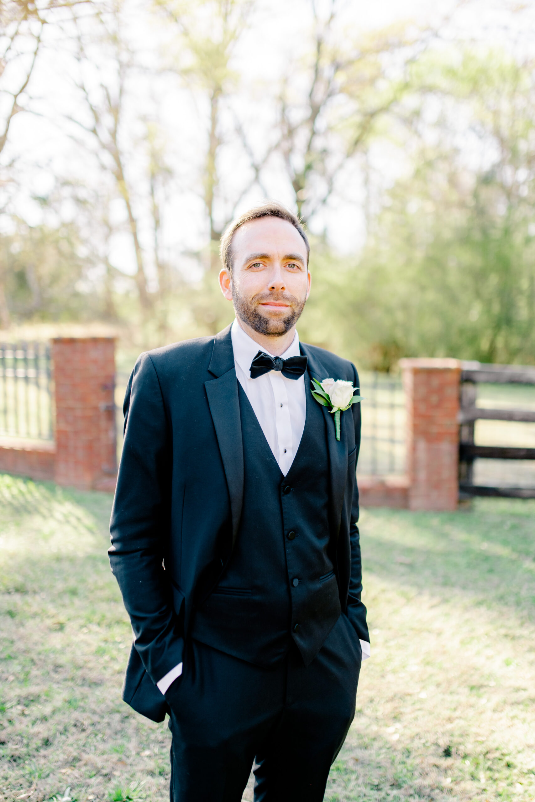 The groom wears a black tuxedo for this spring wedding at Marsgate.