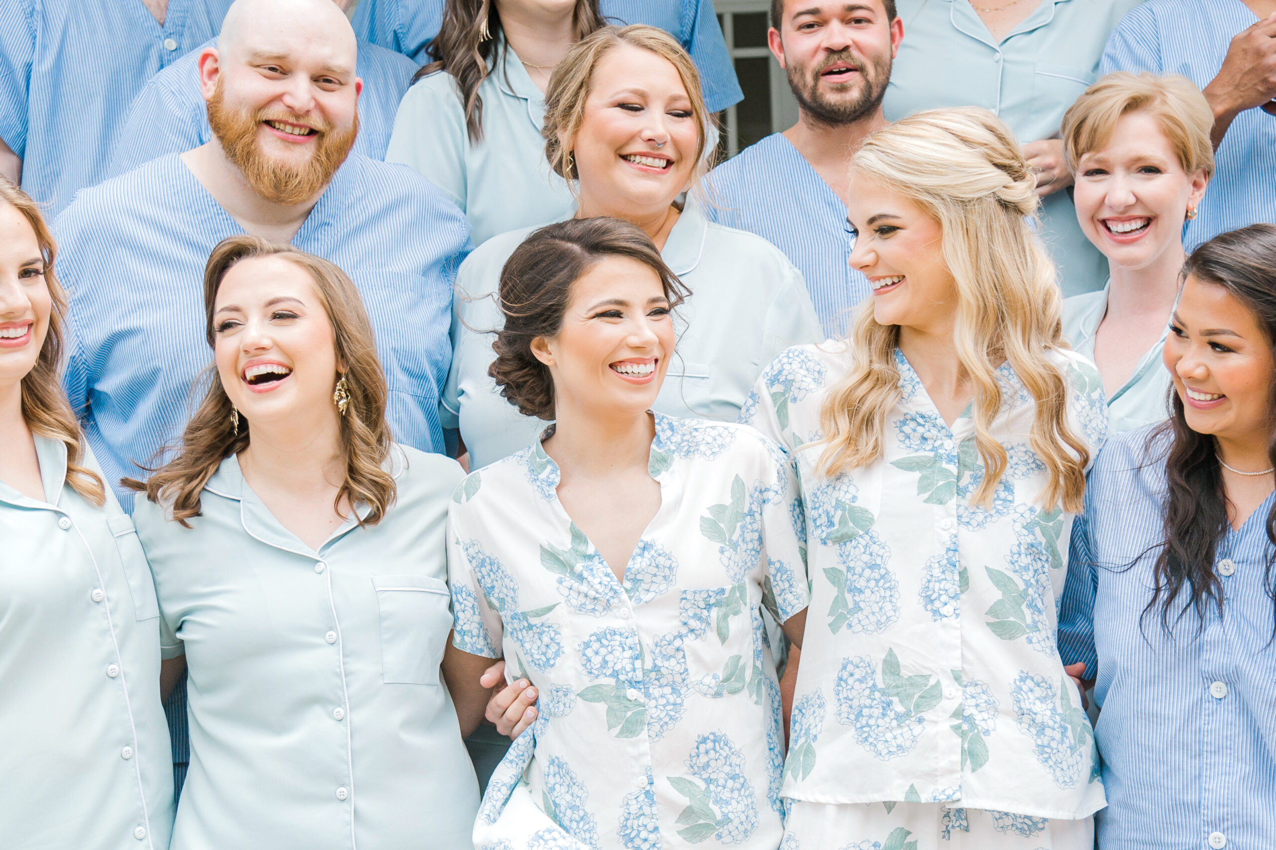 The brides smile with their wedding party while they get ready for the day.