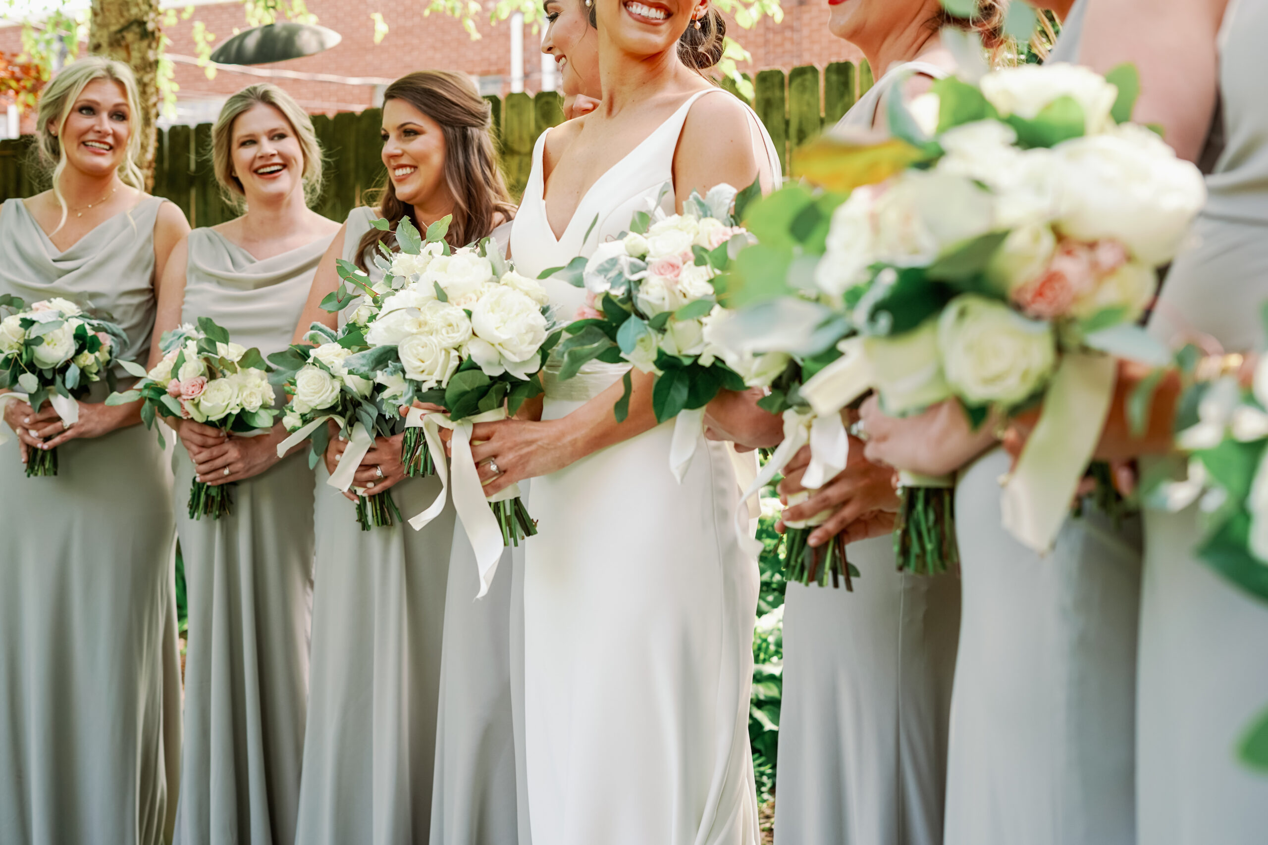 The bridesmaids hold their bouquets with the bride before the Alabama wedding ceremony.