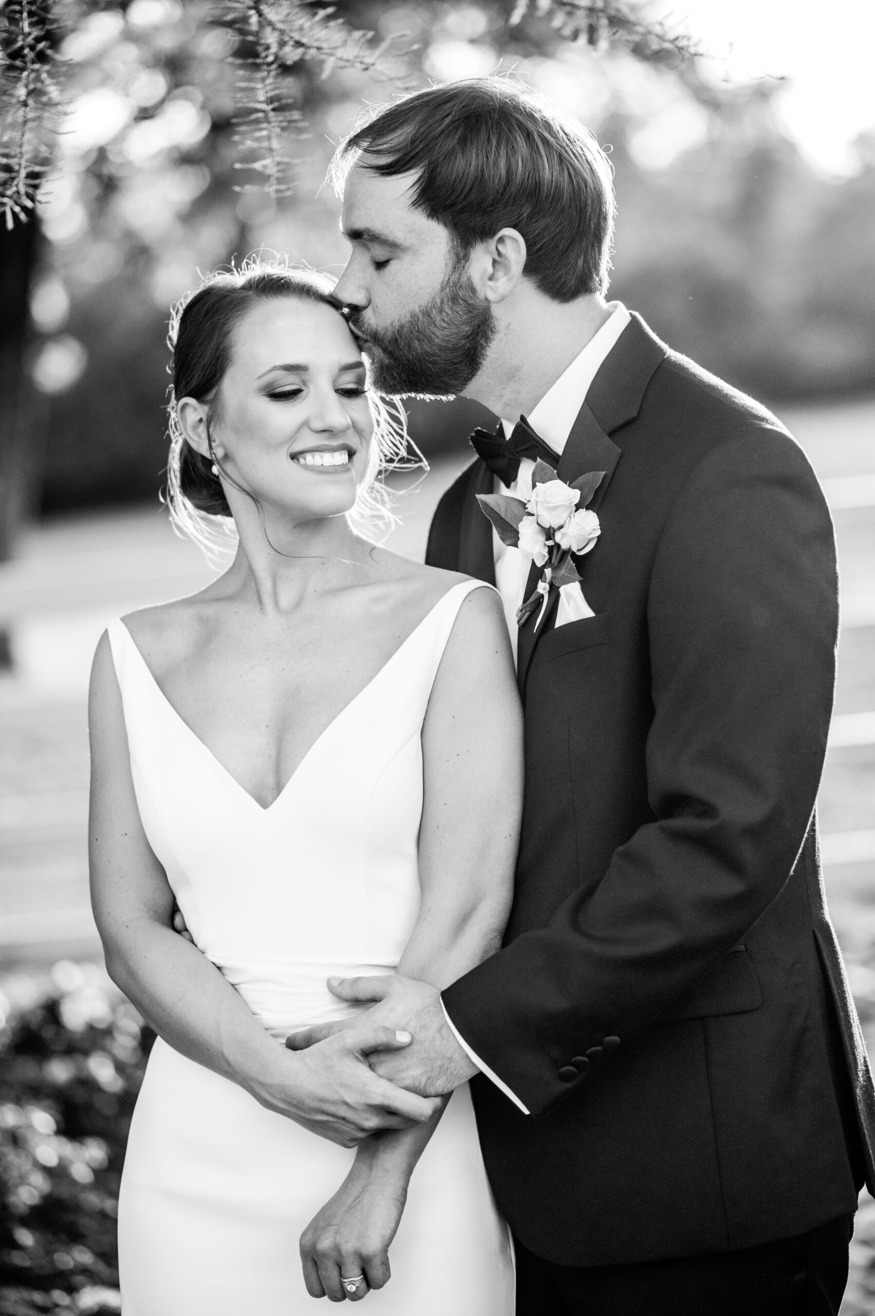 The groom kisses the bride's forehead before their Alabama wedding ceremony.