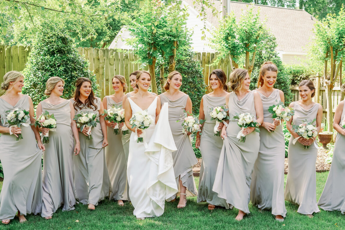 The bridesmaids walk with the bride while holding their bouquets.