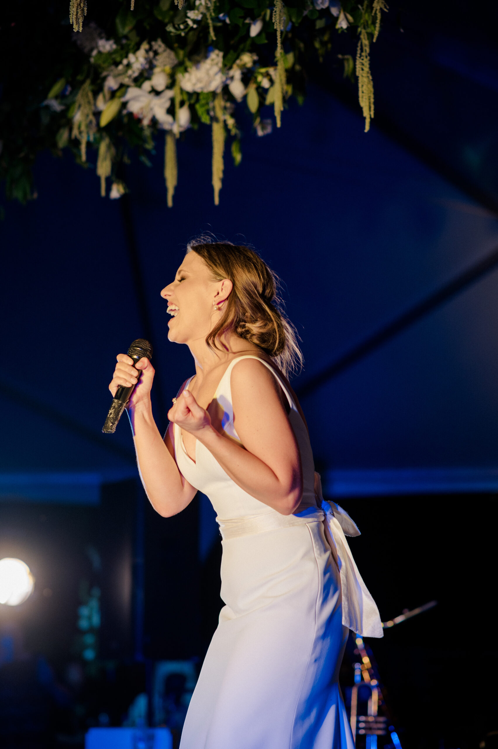 The bride sings on stage during her Alabama wedding reception.