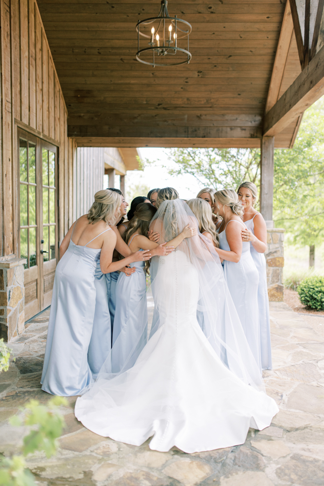 The bridal party hugs the bride before the wedding ceremony at Otter Creek Farmstead.