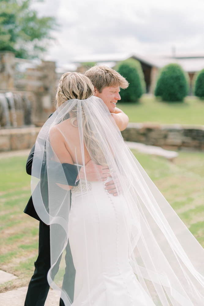 The bride and groom embrace before their Southern wedding ceremony at Otter Creek Farmstead.