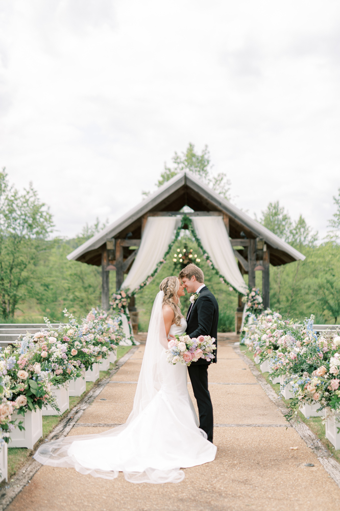 The bride and groom stand together in front of their wedding ceremony at Otter Creek Farmstead.