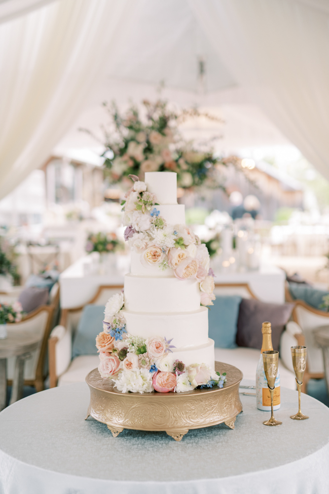 A classic wedding cake is decorated with pastel flowers for a Southern wedding reception at Otter Creek Farmstead.