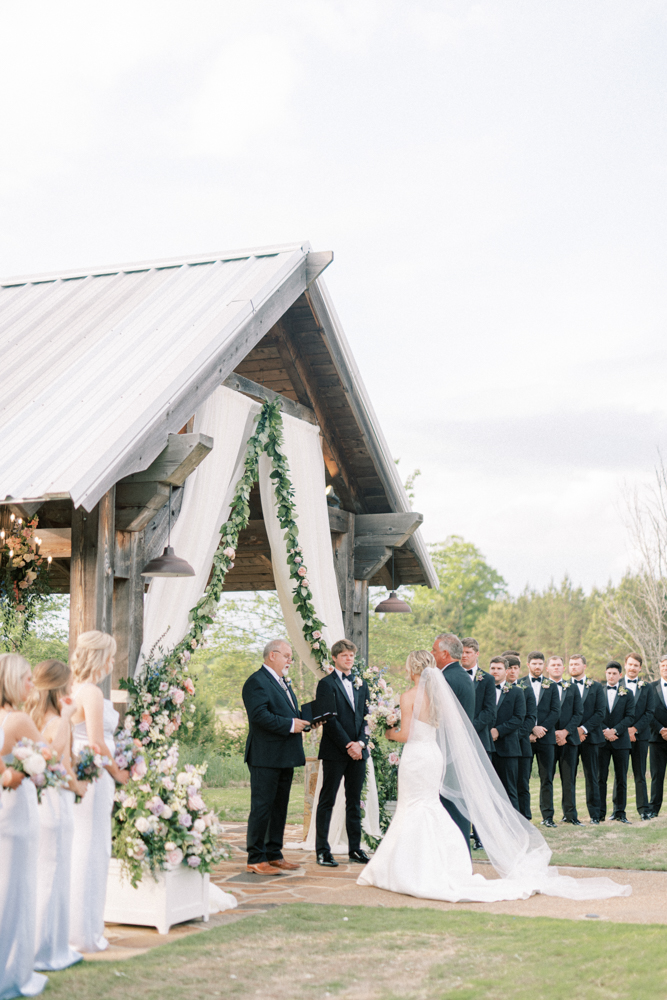 The Southern wedding ceremony at Otter Creek Farmstead is decorated with pastel flowers and greenery.