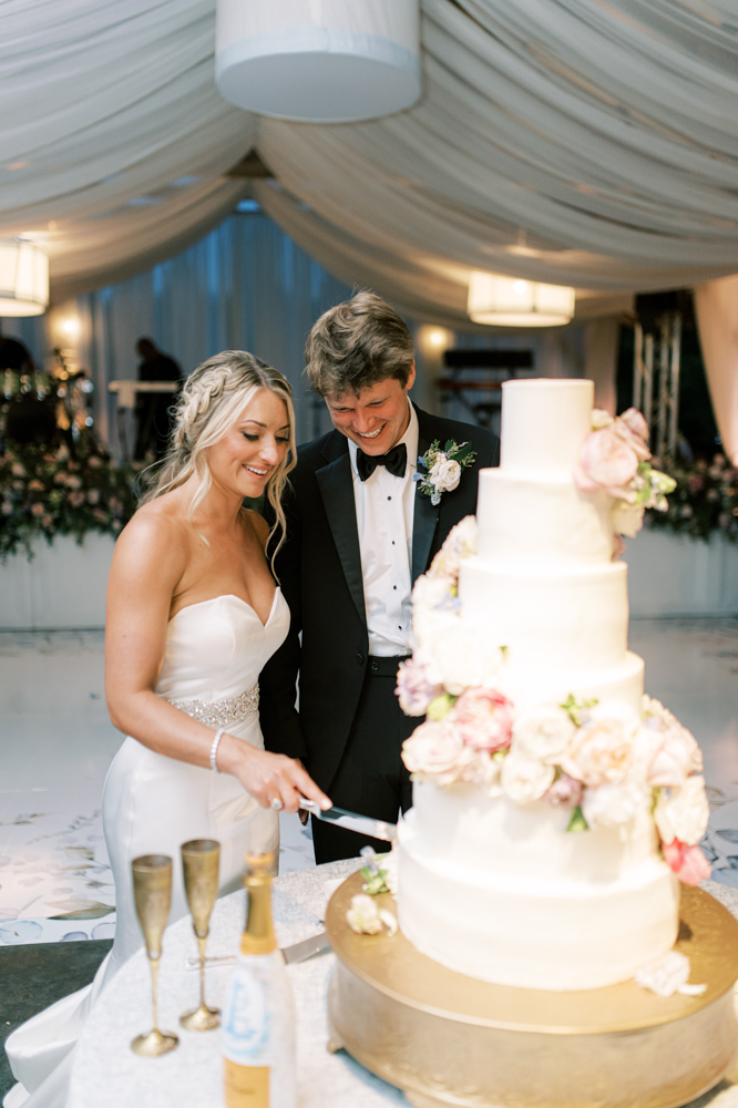 The couple cuts the cake during their Otter Creek Farmstead wedding in Ohatchee, Alabama.