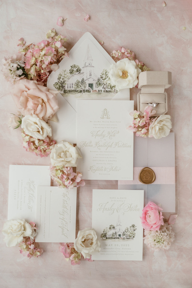 The wedding invitations are styled in a lay flat with classic Southern engraving and illustrations of the wedding venue.