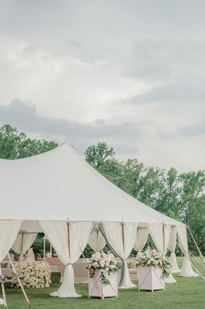 The wedding reception tent is decorated with white and pink flowers in Alabama.